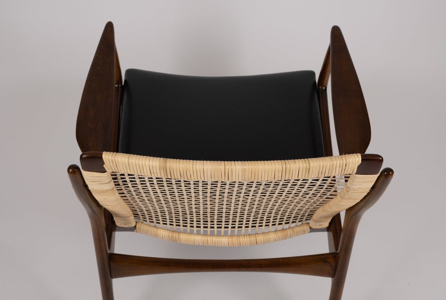 Top view of Ib Kofod Larsen model 18-15 cane armchair with teak frame and original black faux leather seat