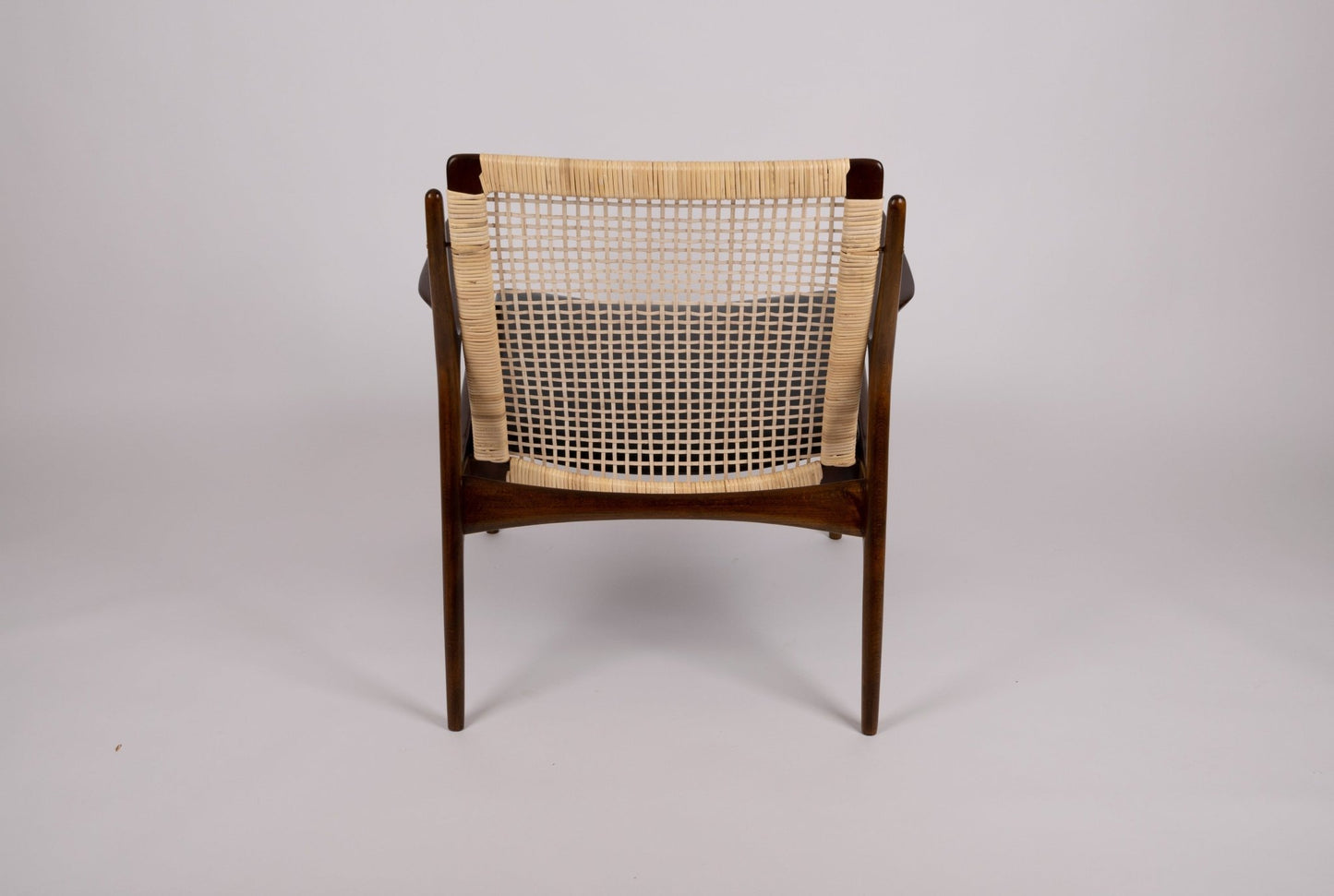 Rear view of Ib Kofod Larsen model 18-15 cane armchair with teak frame and original 1960s faux leather seat by Selig Denmark
