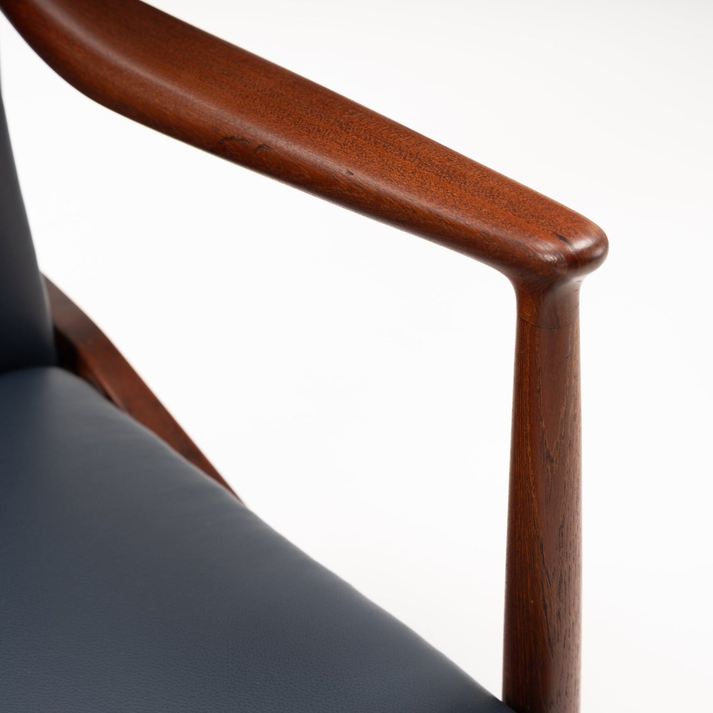 Jacob Kjaer Adjustable Lounge Chair close detail of black leather upholstery and sculpted warm wood armrest in mid century modern furniture style