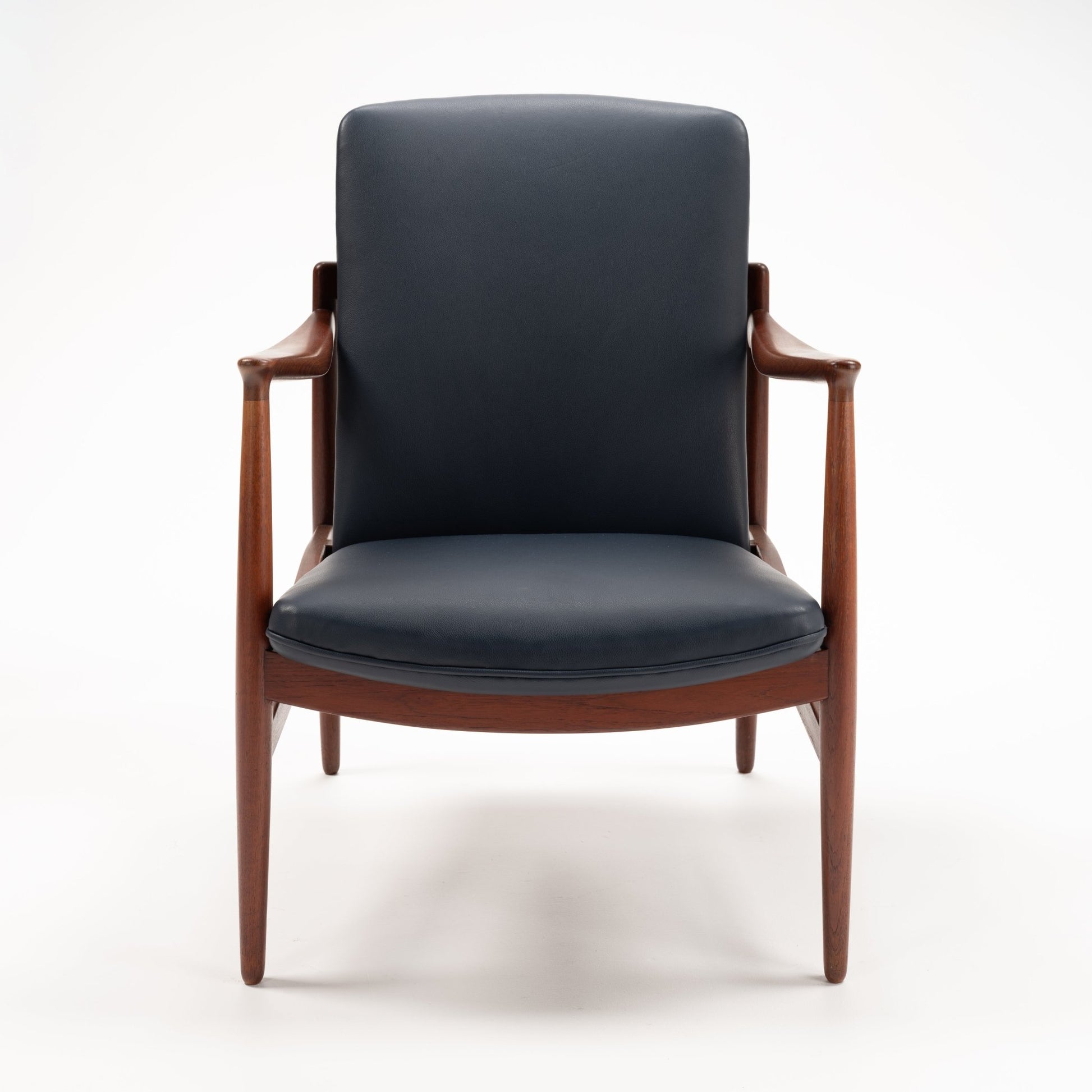 Jacob Kjaer Adjustable Lounge Chair with black leather upholstery exposed warm wood frame sculpted arms and tapered legs in mid century modern furniture style