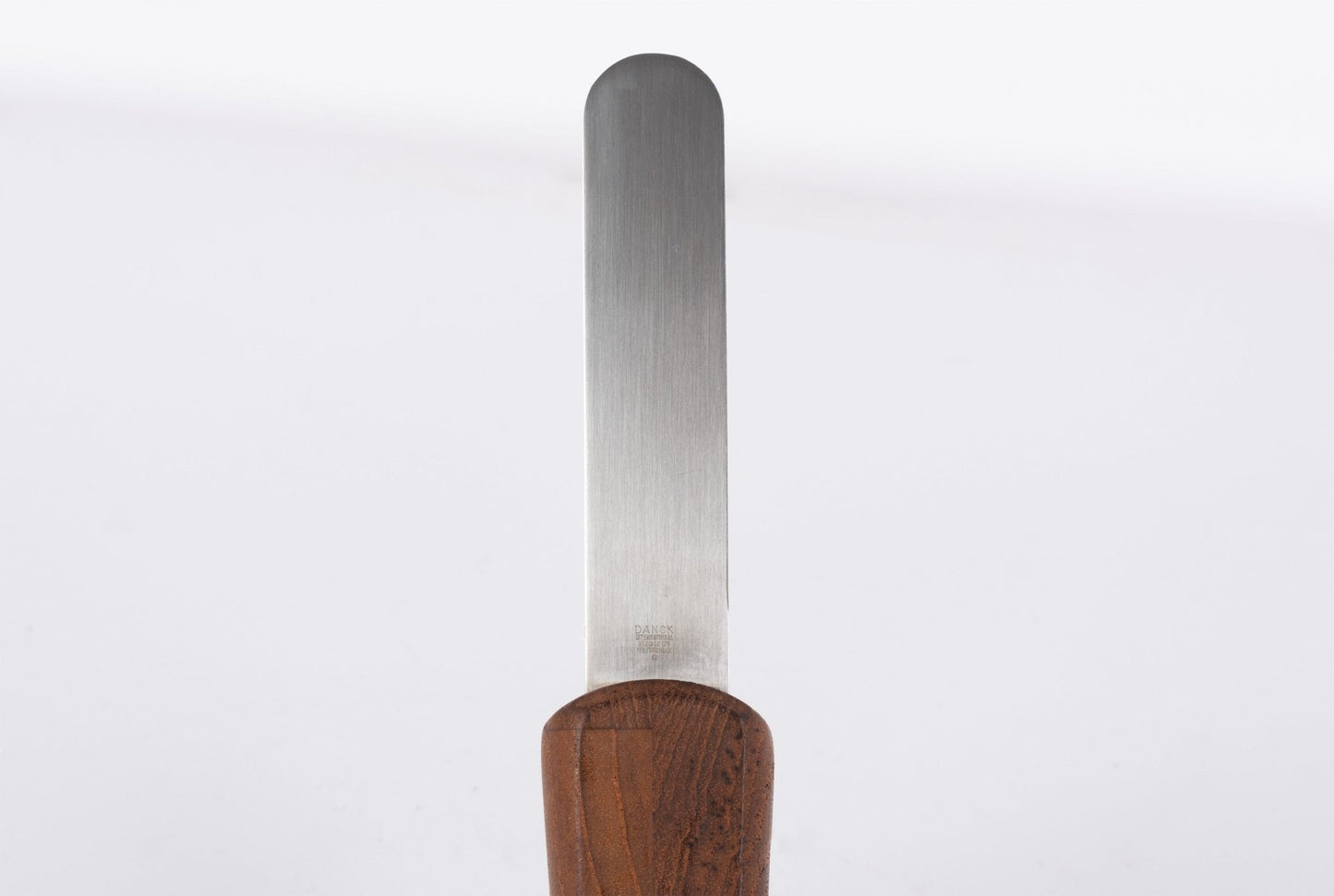 Mid-century modern cheese knife with stainless steel blade and solid teak wood handle on white background