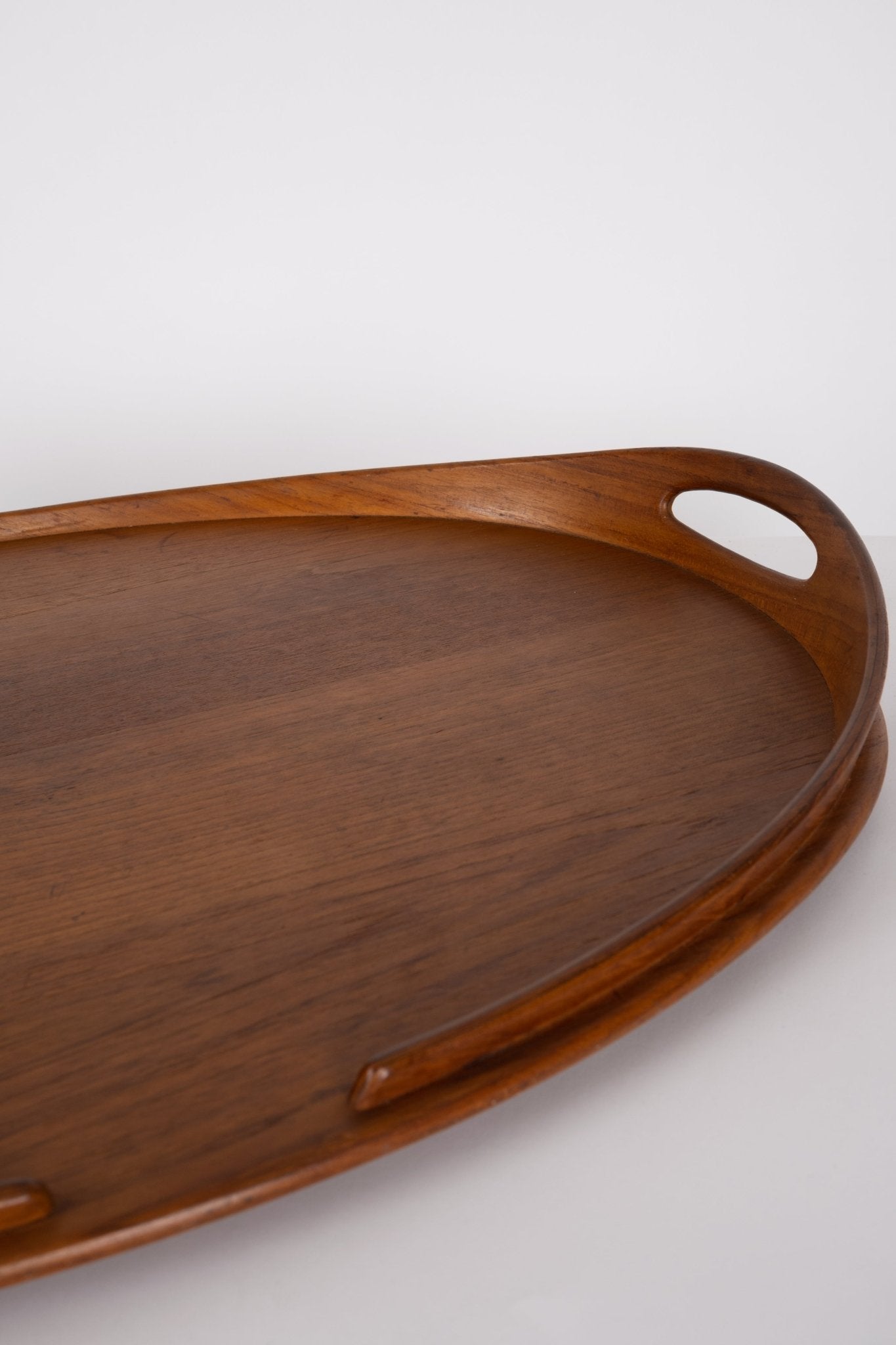 Large oval teak tray by Jens Quistgaard for Dansk from the 1950s with raised sculpted rim and integrated handles