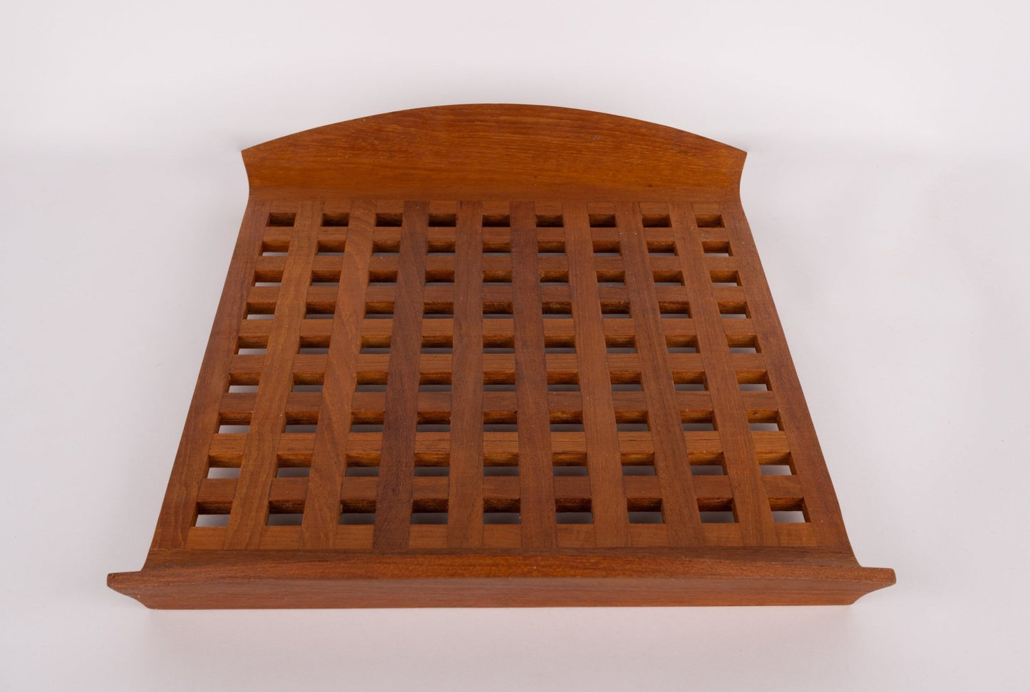Mid-century modern Jens Quistgaard teak lattice serving tray with grid pattern and curved handle edge on white background