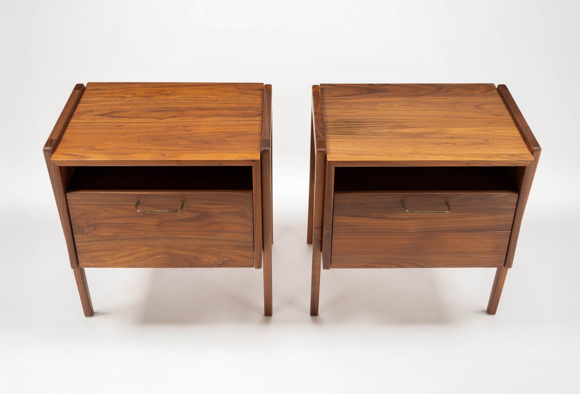 Pair of Jens Risom walnut bedside tables with open compartments and fall-front drawers, circa 1960s design.