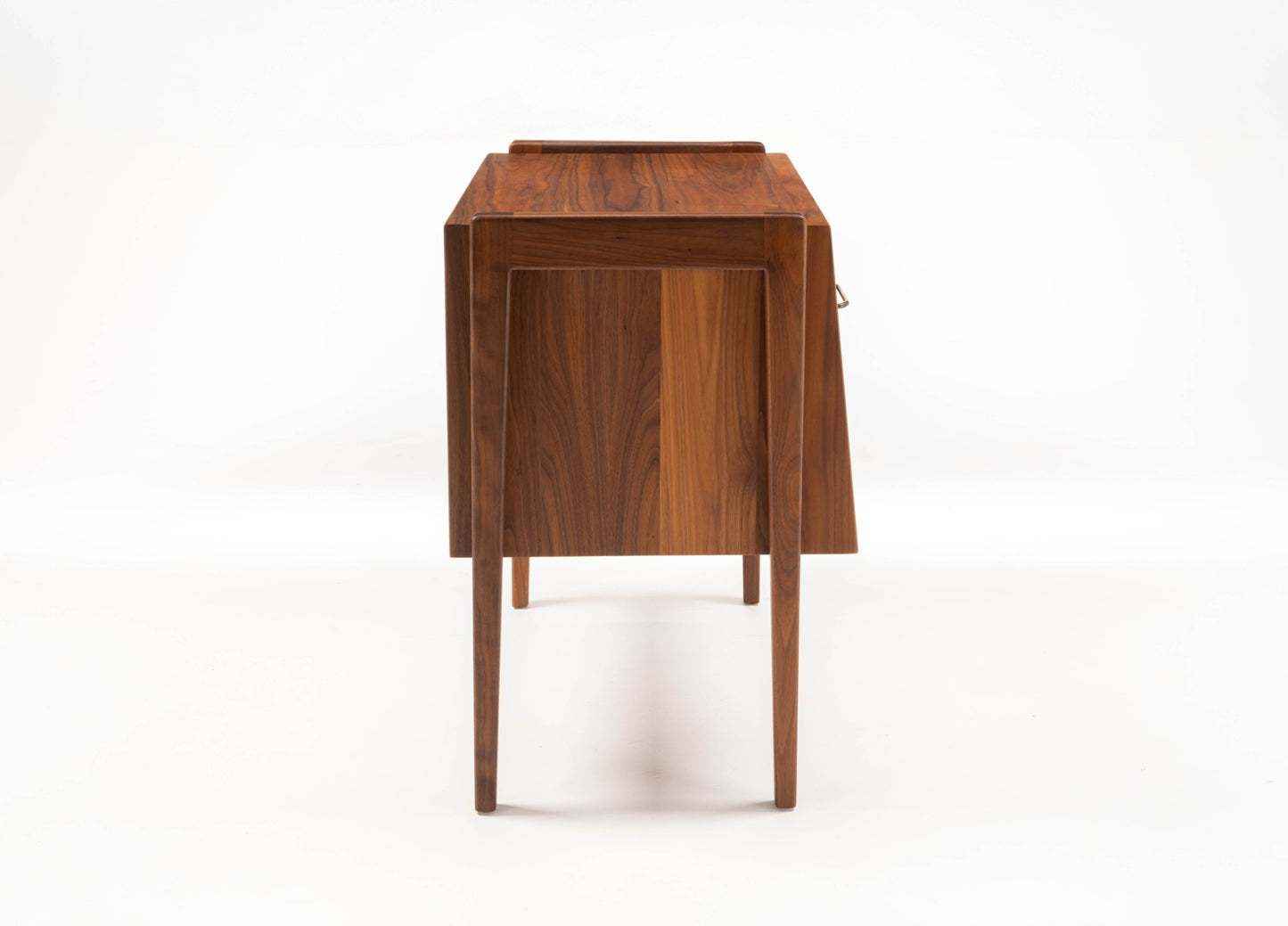 Pair of mid-century modern walnut bedside tables by Jens Risom with tapered legs and clean lines on white background