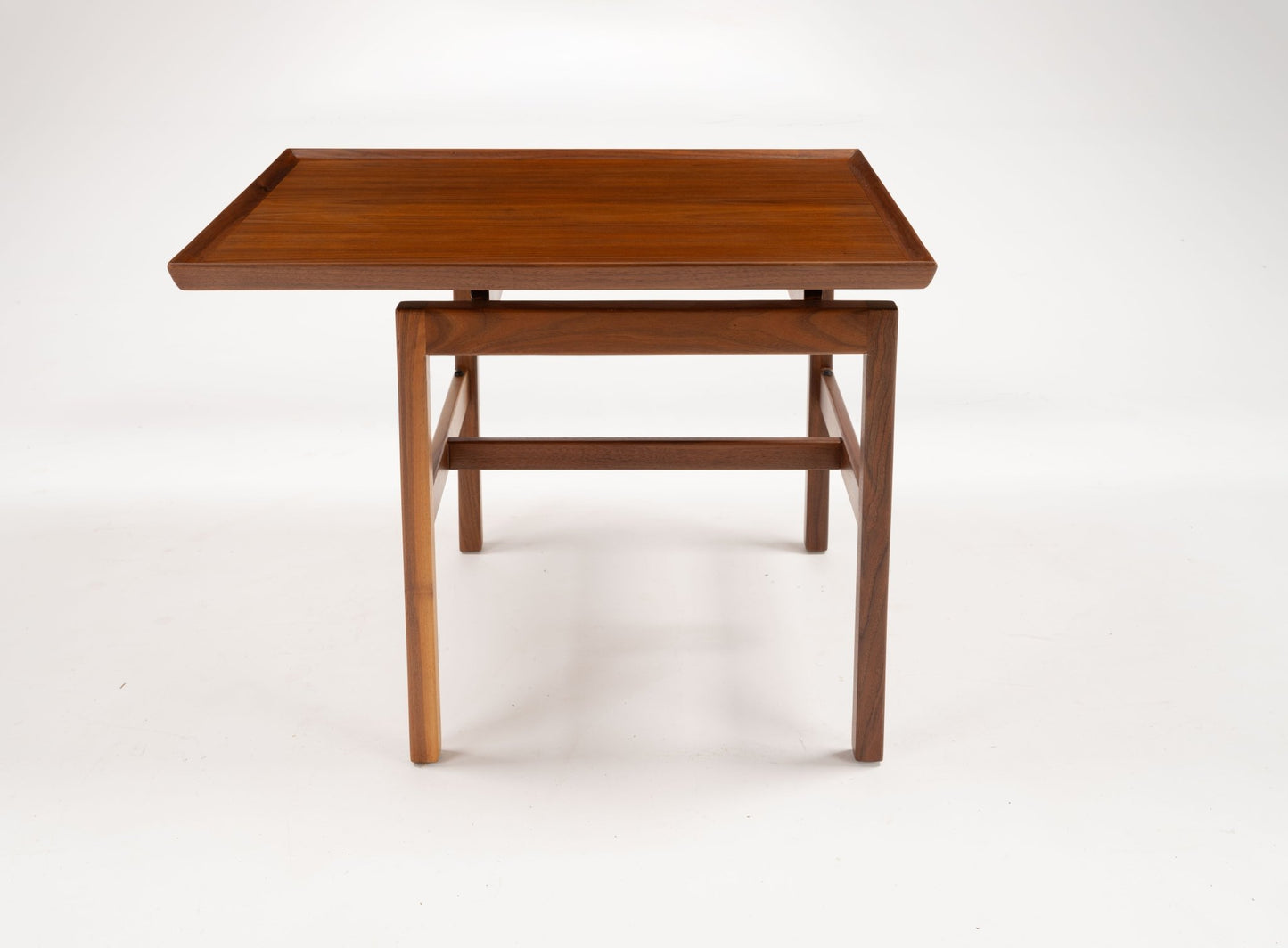 Mid-century modern Jens Risom cantilever side table with walnut wood, off-center rectangular top, and shallow gallery edge.