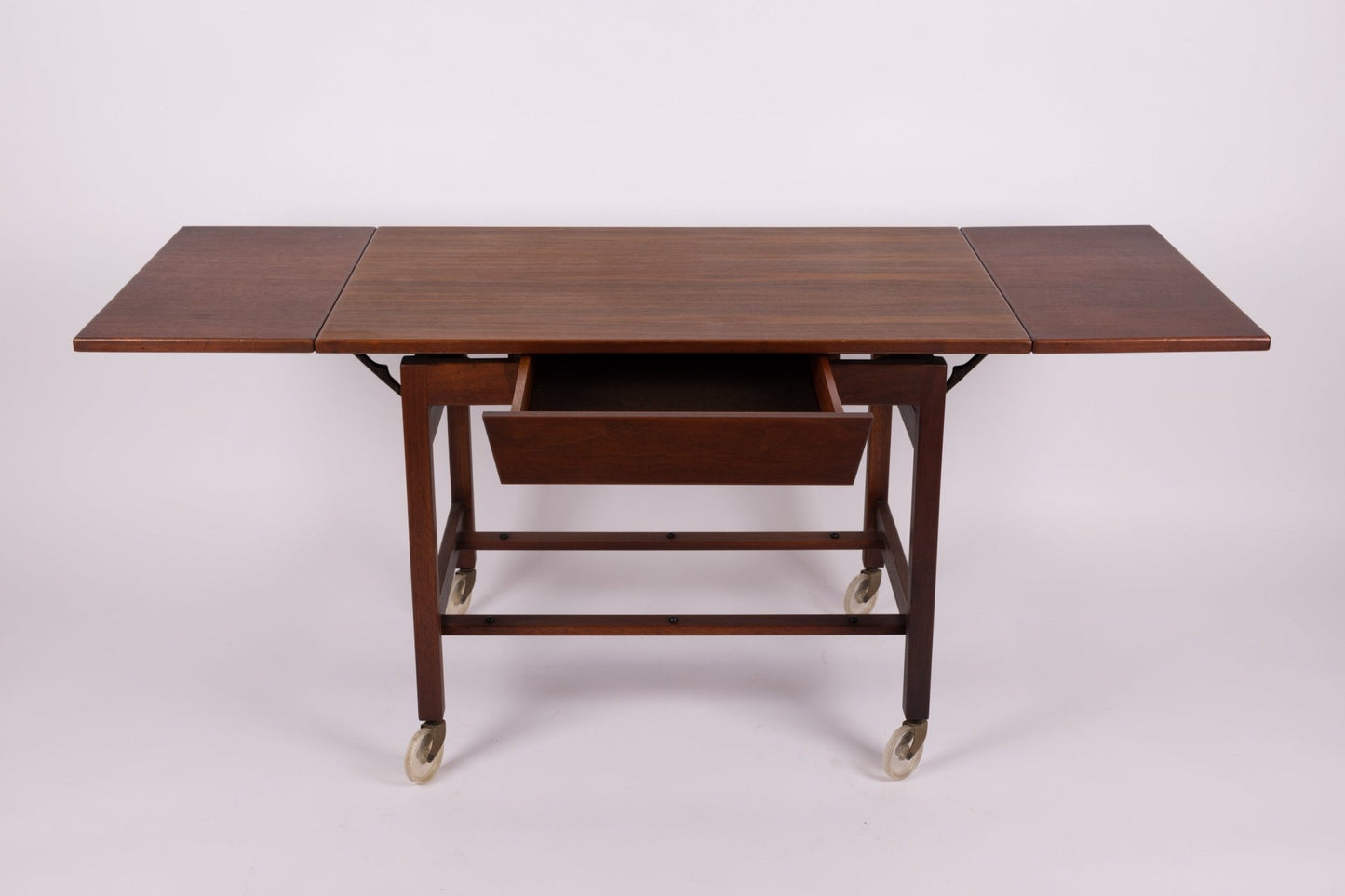 1960s Jens Risom expandable wooden serving cart with side leaves extended and caster wheels from the United States