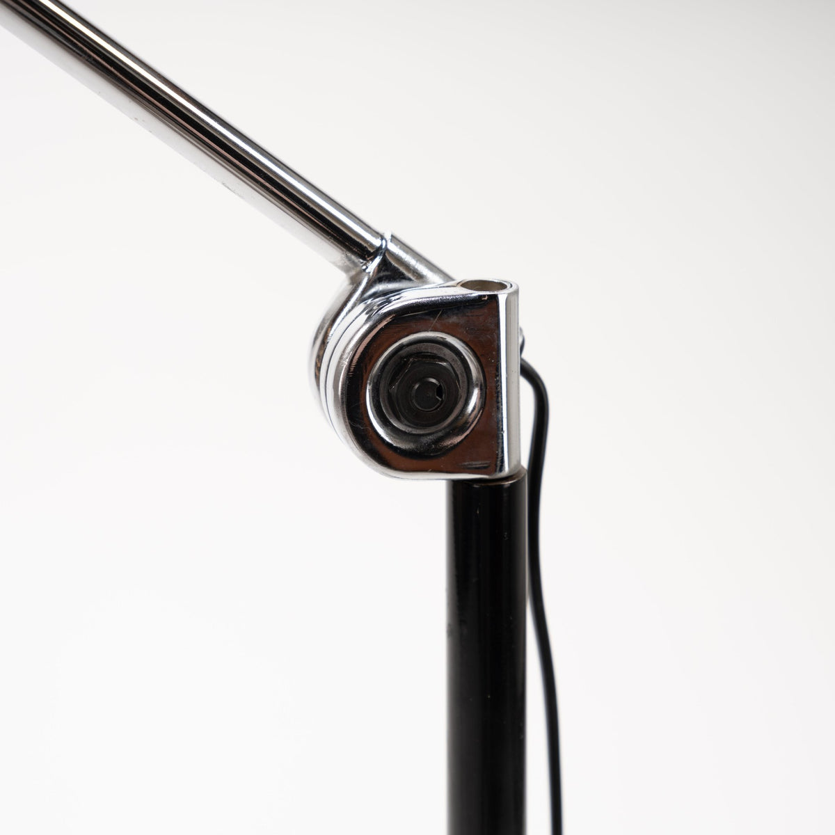 Joe Colombo Chrome Topo Floor Lamp closeup of polished chrome pivot joint black vertical stem and visible power cord in mid century modern lighting