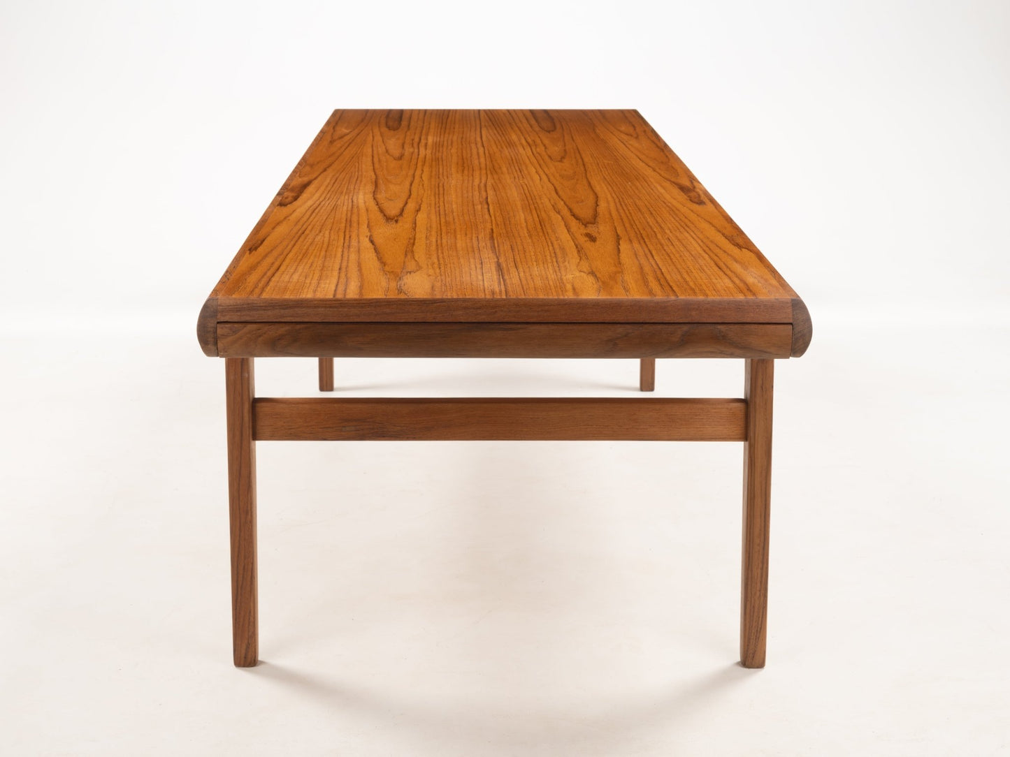 Rectangular teak coffee table with gently rounded edges and simple tapered legs showcasing Danish 1960s design craftsmanship