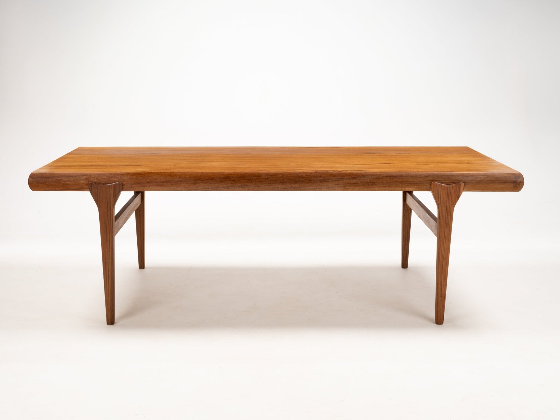 Rectangular teak coffee table with rounded edges and tapered legs showcasing Danish mid-century style craftsmanship