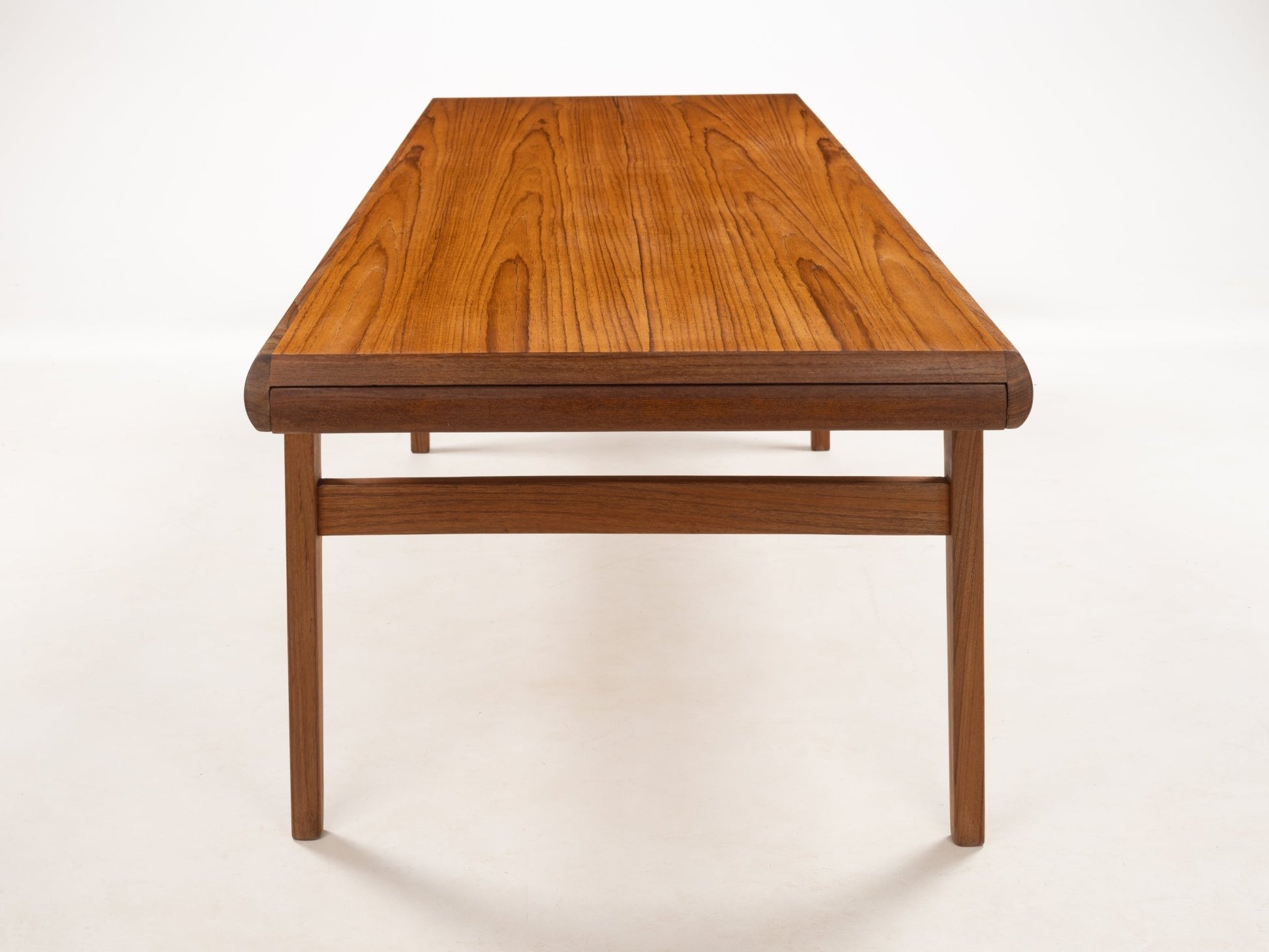Rectangular teak coffee table with softly rounded corners and pronounced wood grain showcasing Danish mid-century design