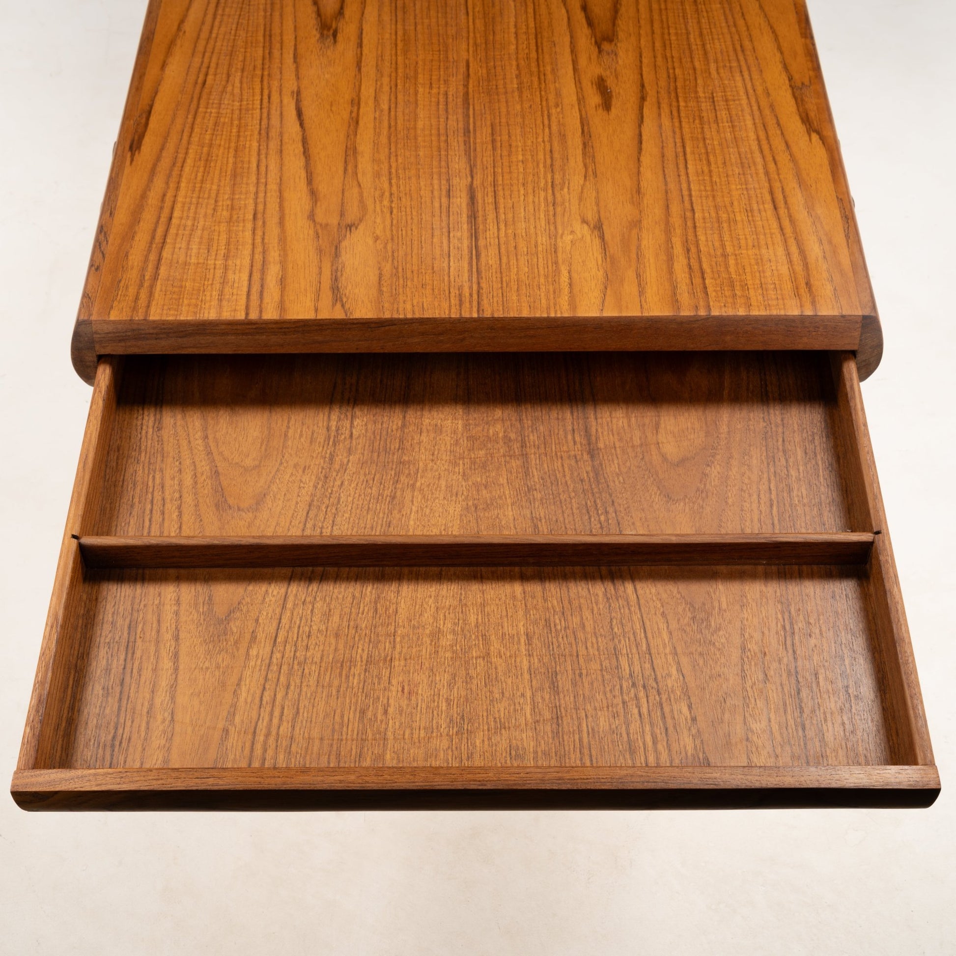 Open drawer of Johannes Andersen teak coffee table highlighting natural wood grain and minimalist Danish mid-century style