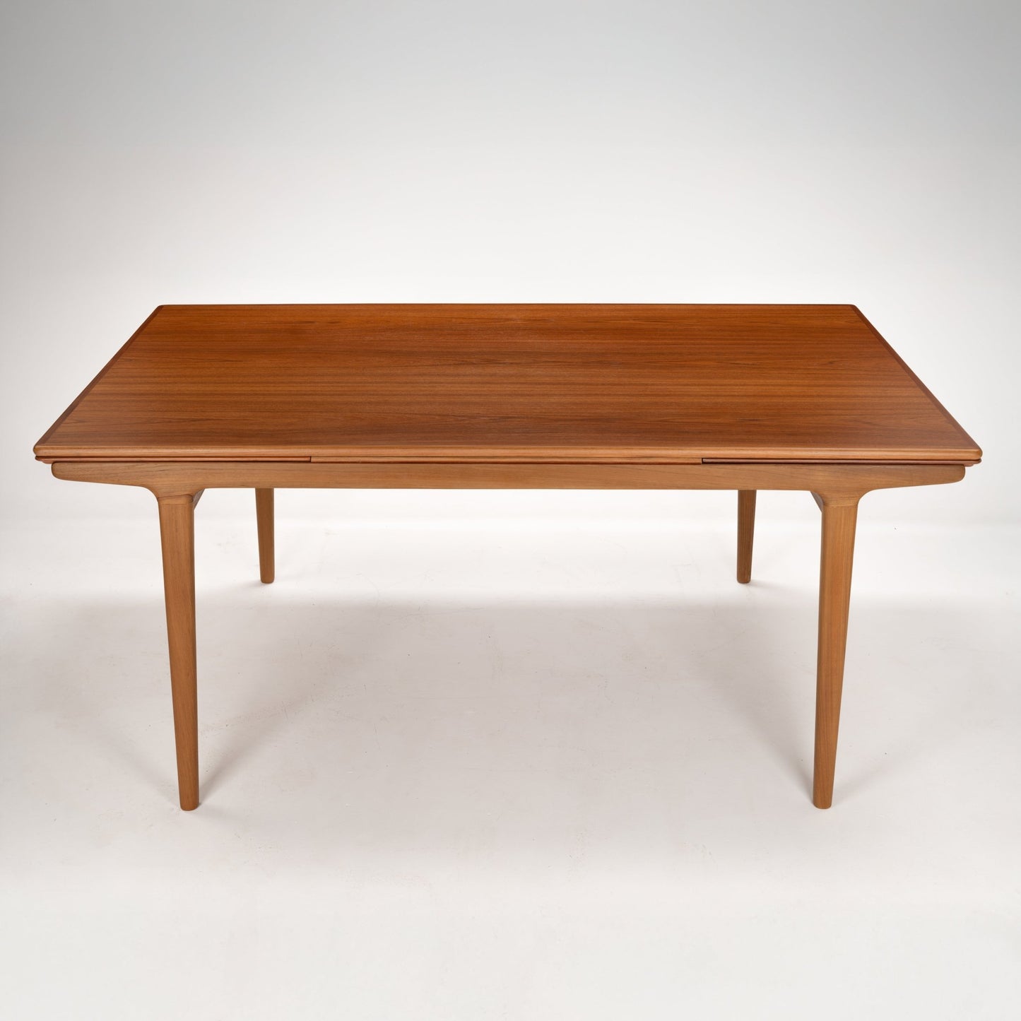 Rectangular wooden dining table with tapered legs and smooth surface in a warm medium brown finish