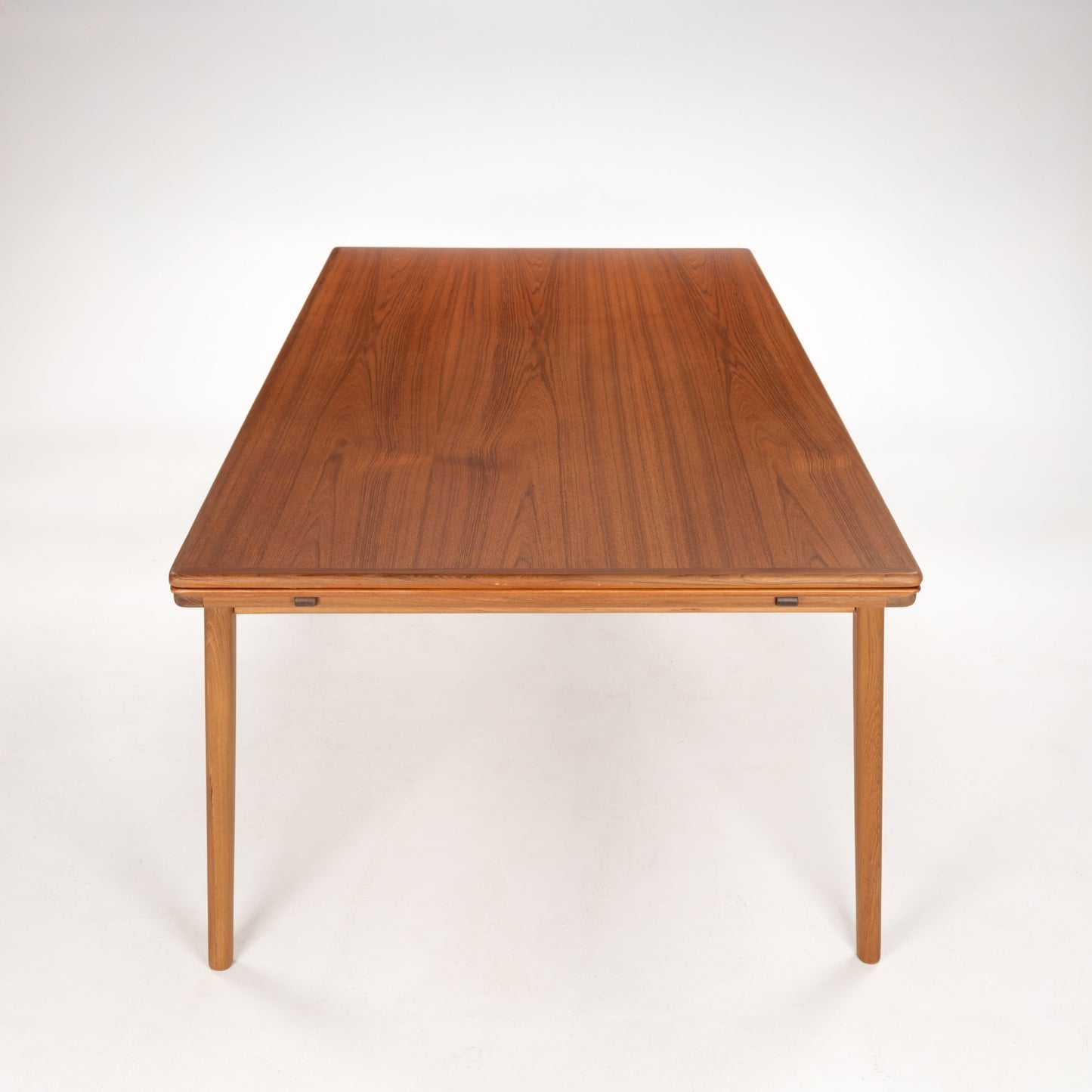 Rectangular wooden dining table with slender legs and smooth polished surface in a medium brown finish