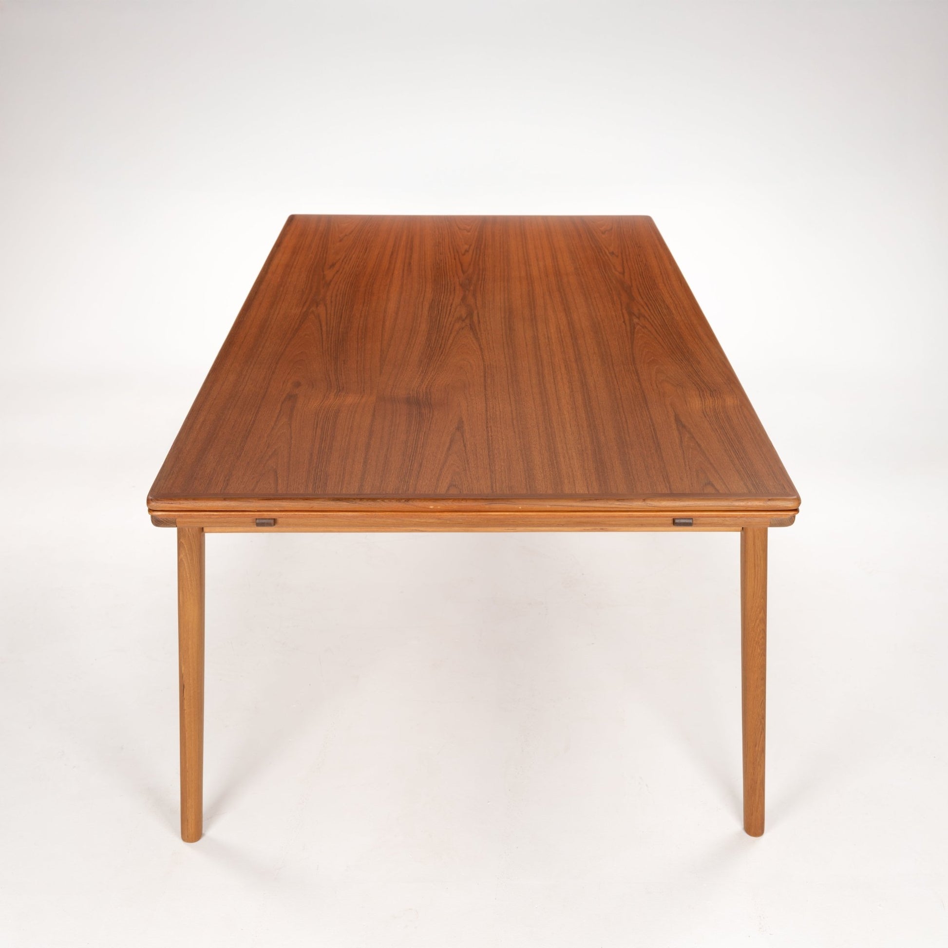 Rectangular wooden dining table with slender legs and smooth polished surface in a medium brown finish