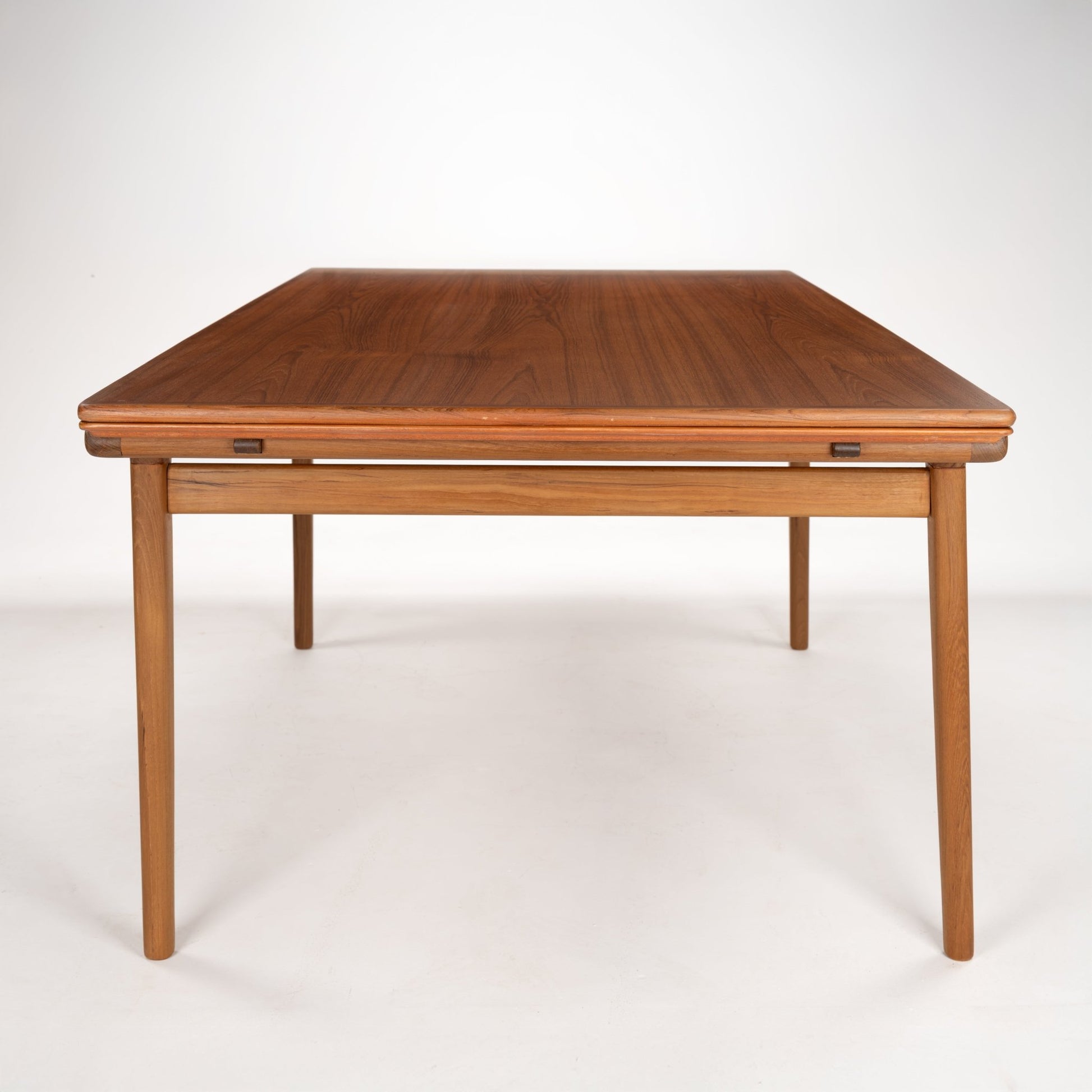 Square mid-century wooden table with tapered legs and warm walnut finish on a white background