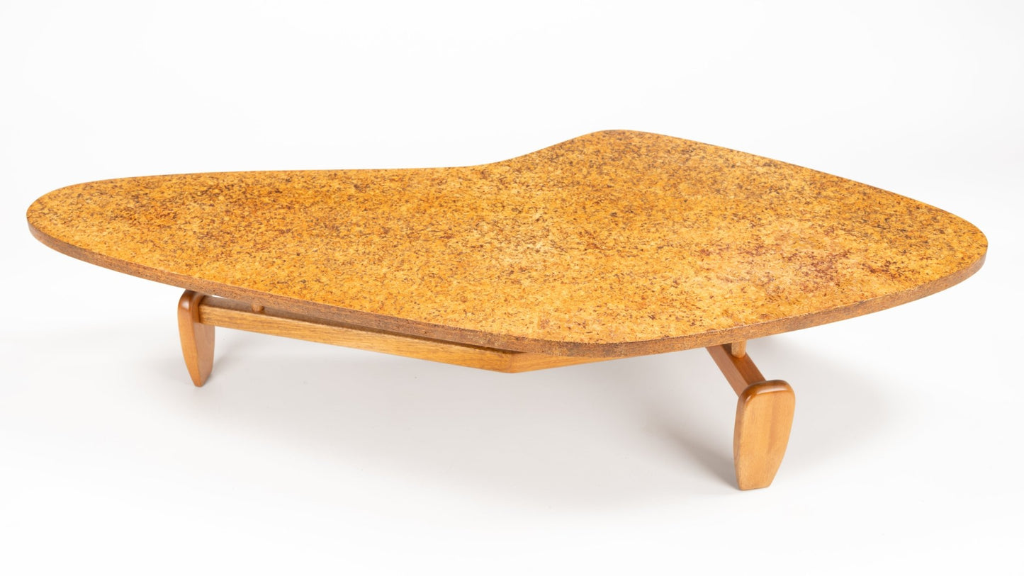 John Keal 'Outrigger' Coffee Table featuring a broad, curved cork tabletop with a warm, textured surface, resting on low wooden legs that emphasize sculptural mid century modern style.