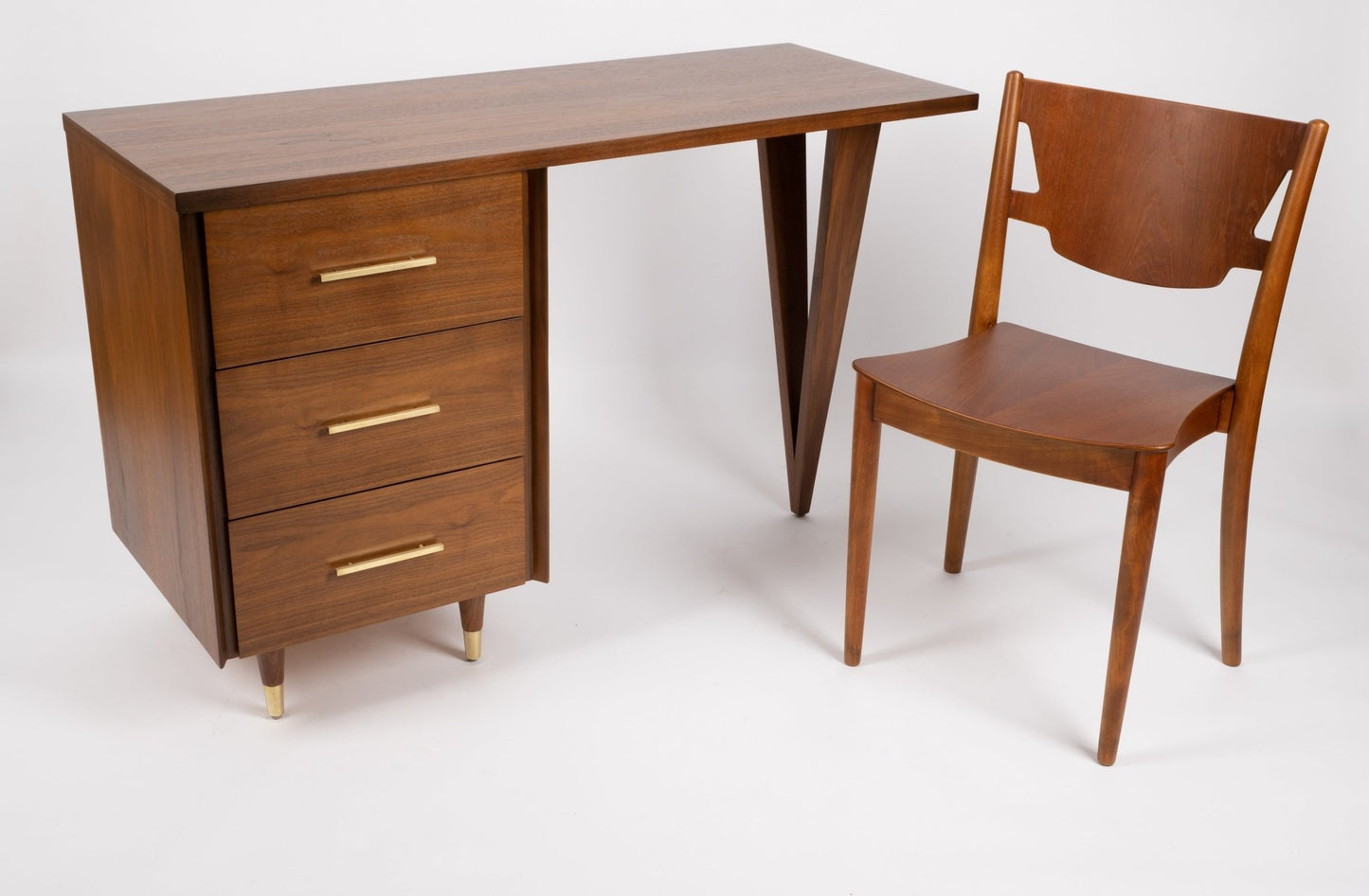 John Stuart mid-century modern desk with triangular legs, three drawers with brass handles, paired with wooden chair