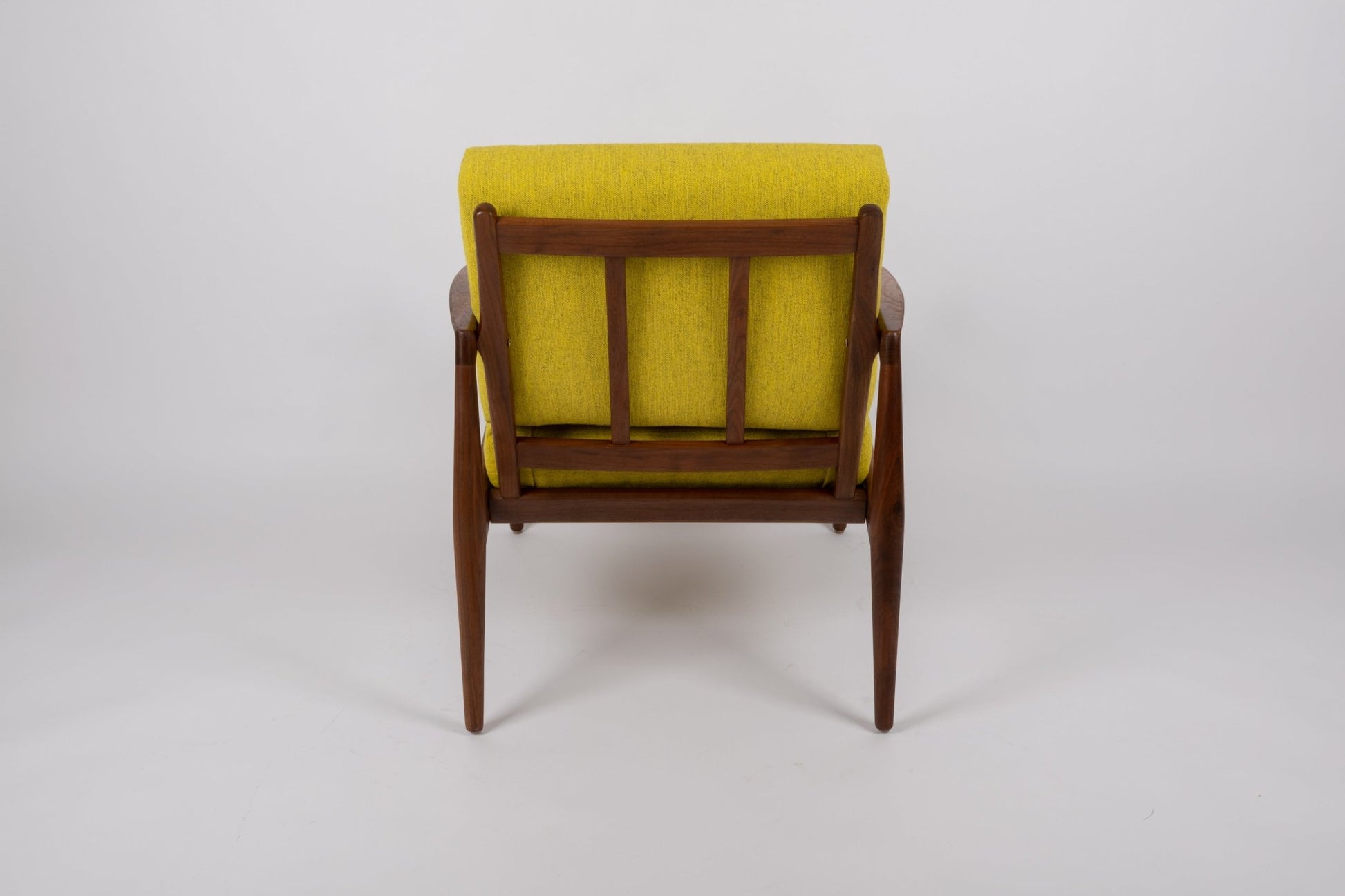 Rear view of Kai Kristiansen 'Paper Knife' chair with teak frame and yellow upholstered seat from 1950s Denmark