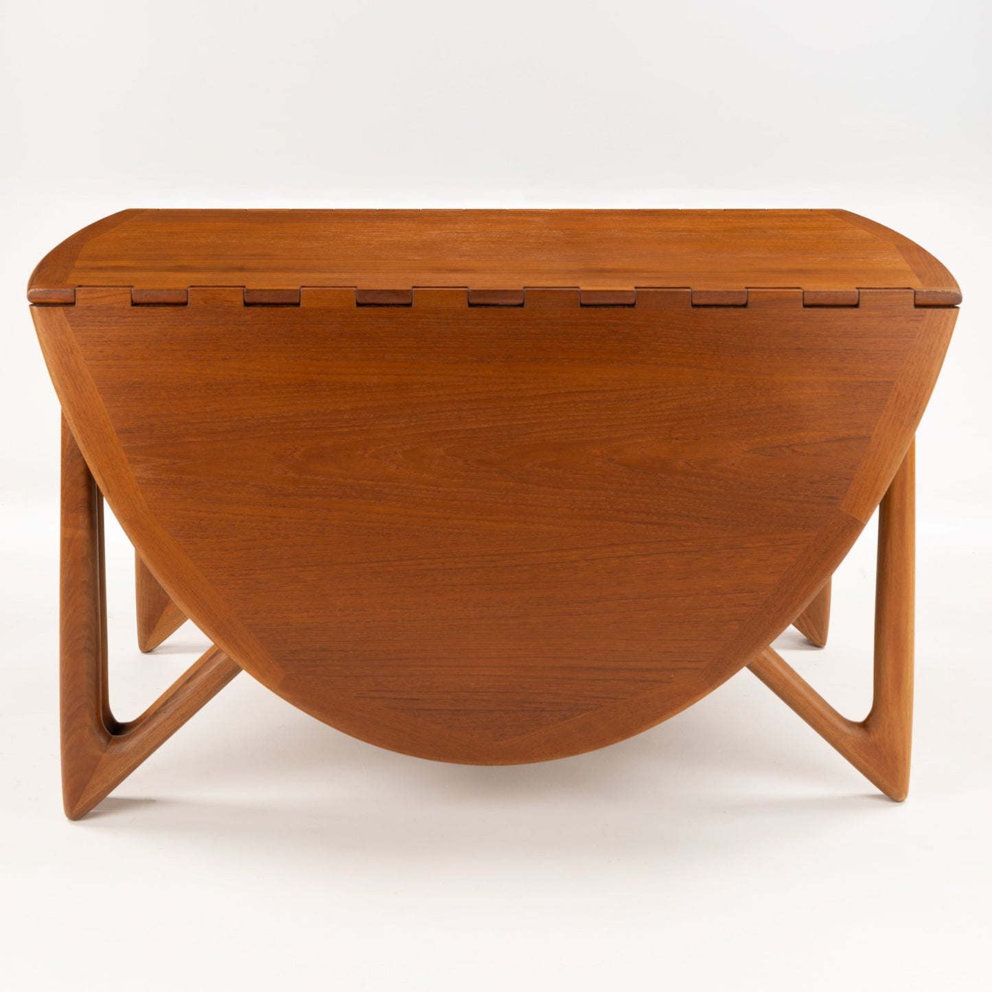 Kurt Ostervig Drop-Leaf Dining Table shown closed with rounded folded leaves sculptural angled legs and warm walnut grain in vintage Danish furniture style