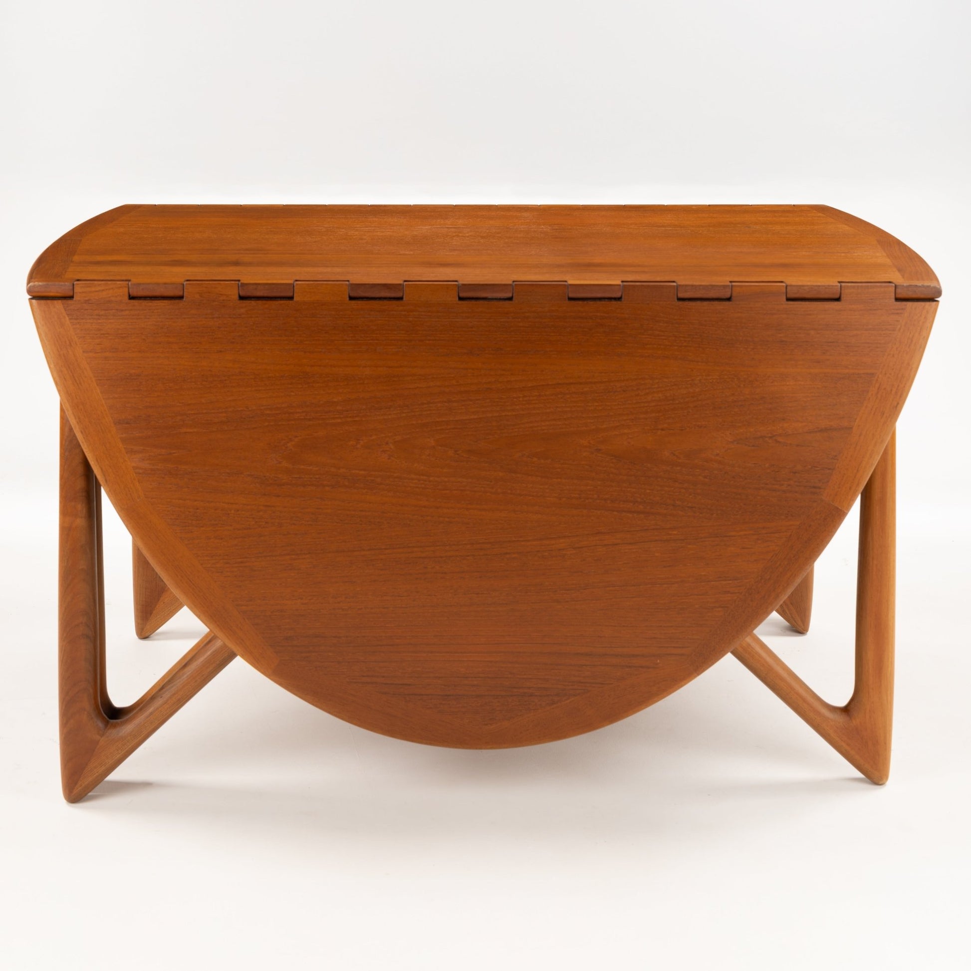Kurt Ostervig Drop-Leaf Dining Table shown closed with rounded folded leaves sculptural angled legs and warm walnut grain in vintage Danish furniture style