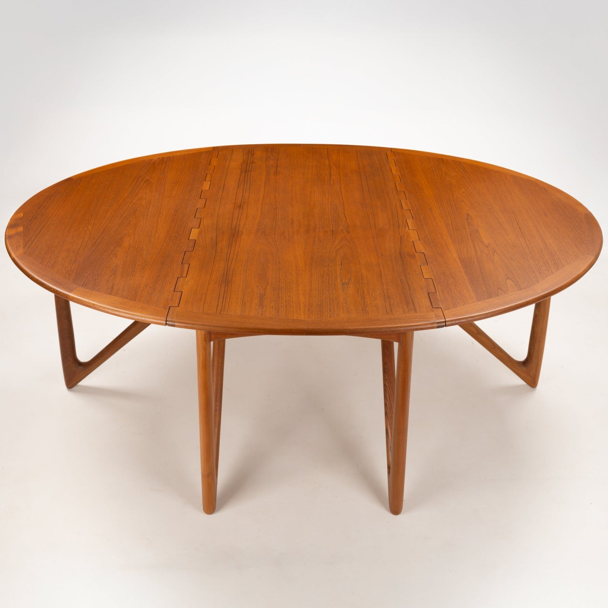 Kurt Ostervig Drop-Leaf Dining Table with oval wood top butterfly leaf seams sculptural angled legs and rich grain in mid century modern furniture style