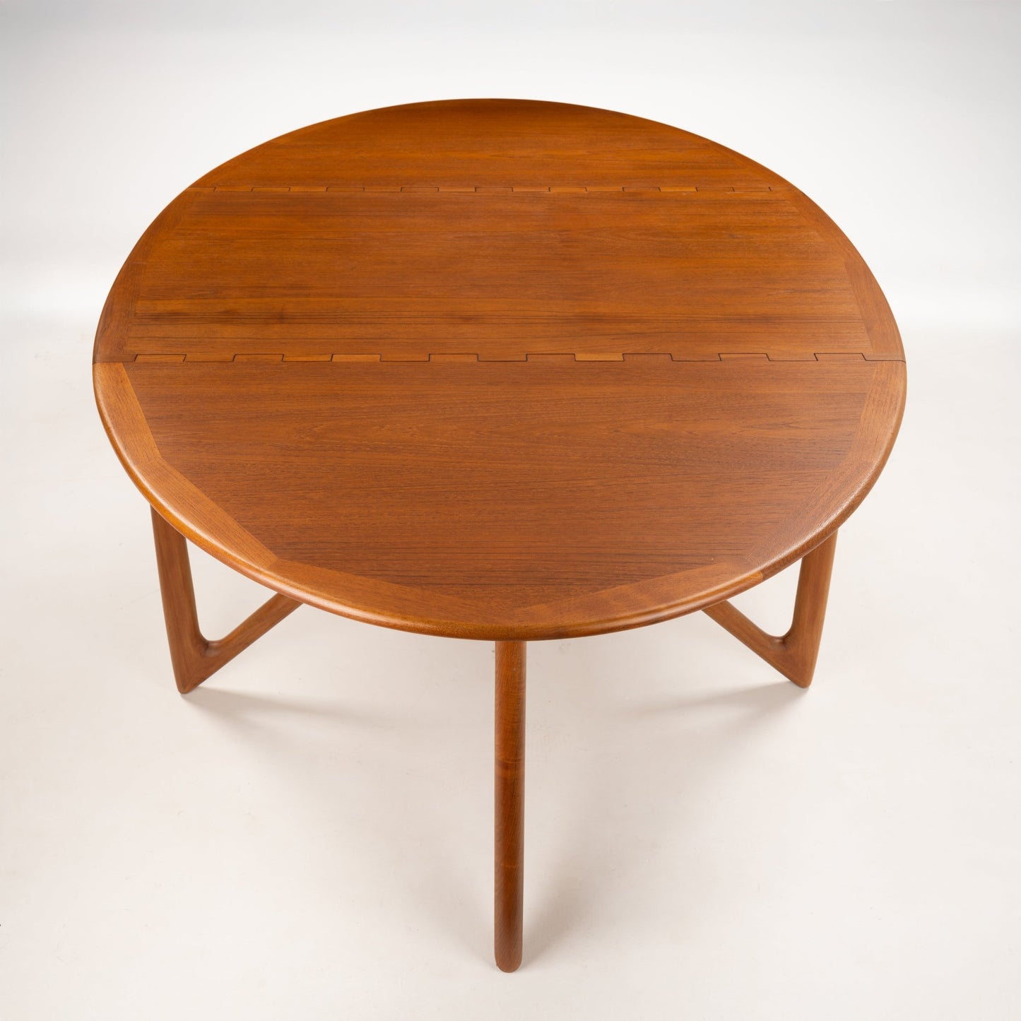 Kurt Ostervig Drop-Leaf Dining Table shown open with oval walnut top angled sculptural legs and visible leaf joinery in mid century modern furniture style
