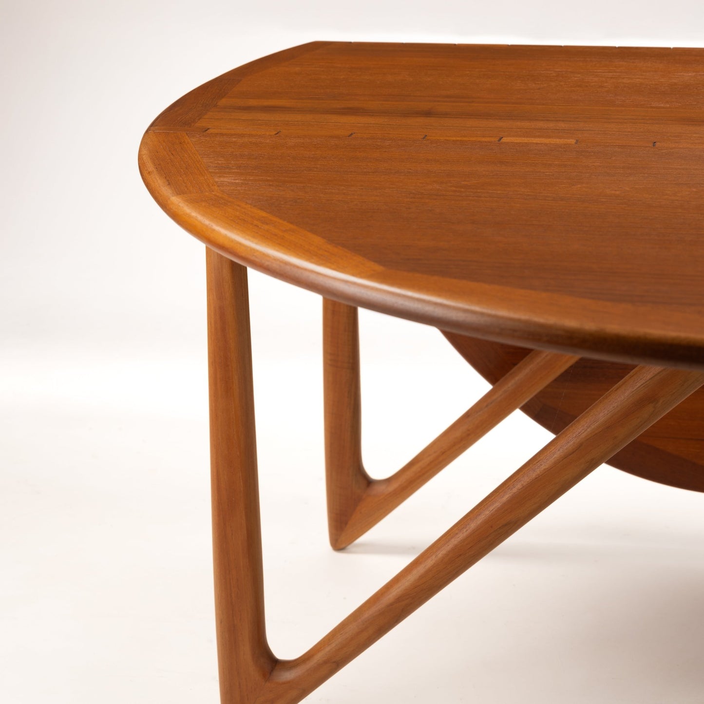 Kurt Ostervig Drop-Leaf Dining Table detail with rounded wood top sculptural angled supports and warm polished grain in mid century modern furniture style