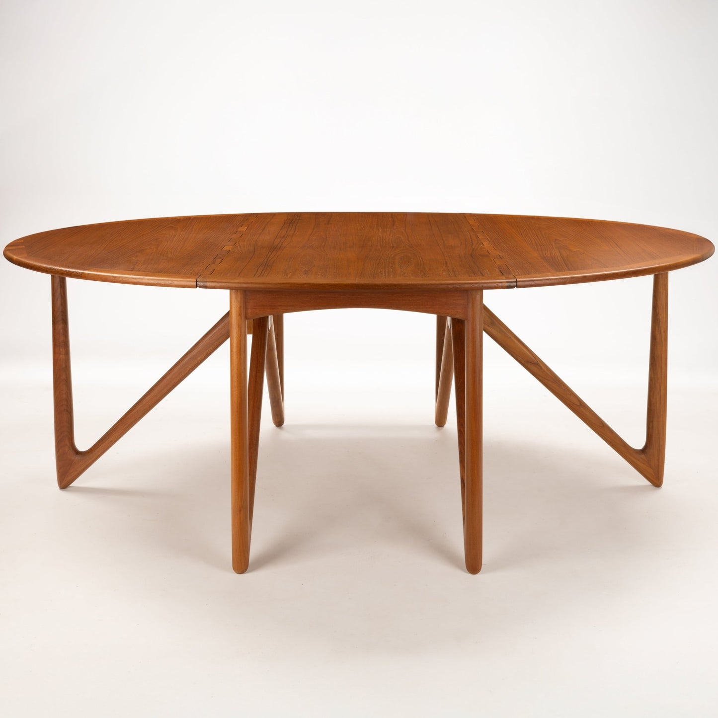 Kurt Ostervig Drop-Leaf Dining Table with extended oval wood top and distinctive angled supports showcasing warm grain in mid century modern furniture style