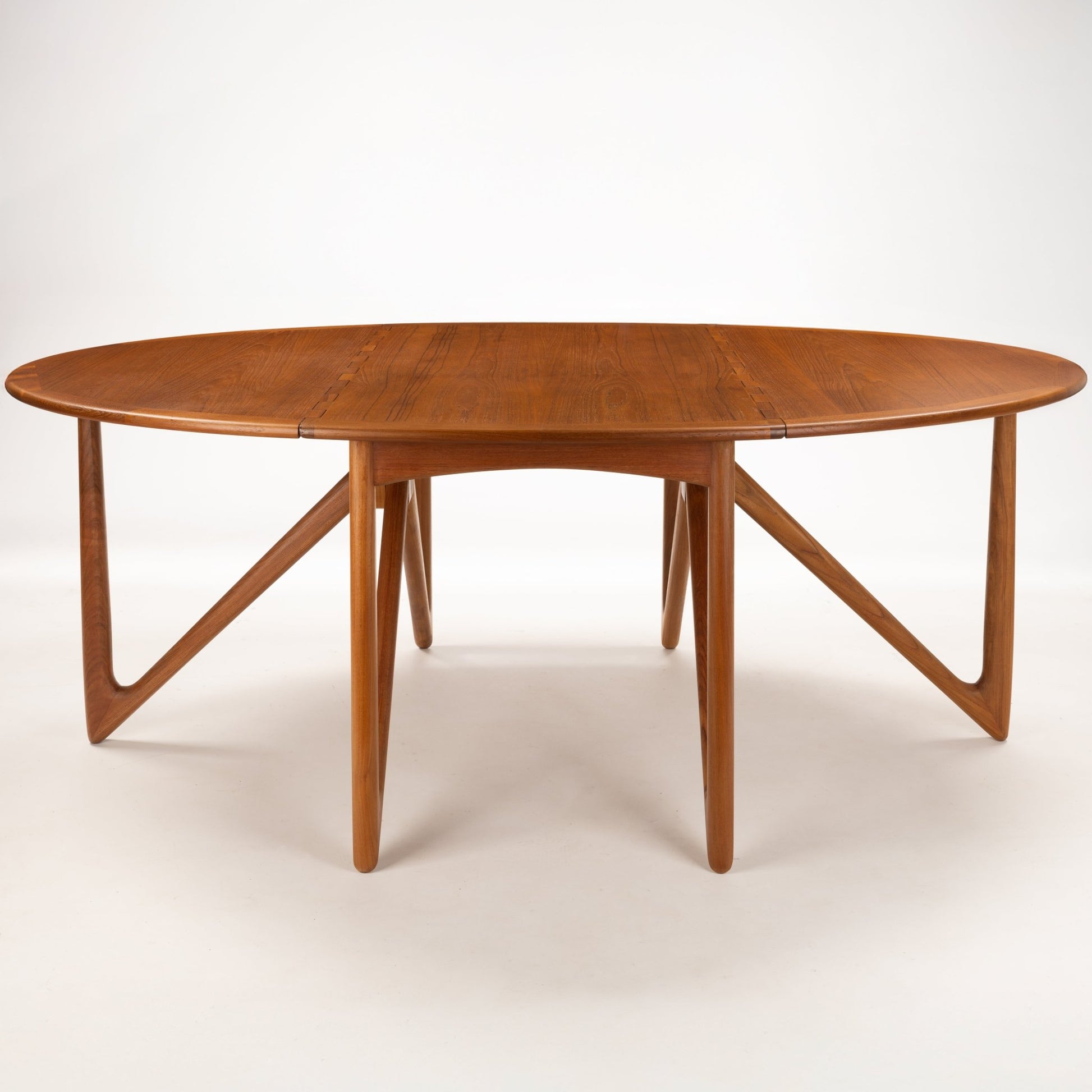 Kurt Ostervig Drop-Leaf Dining Table with extended oval wood top and distinctive angled supports showcasing warm grain in mid century modern furniture style