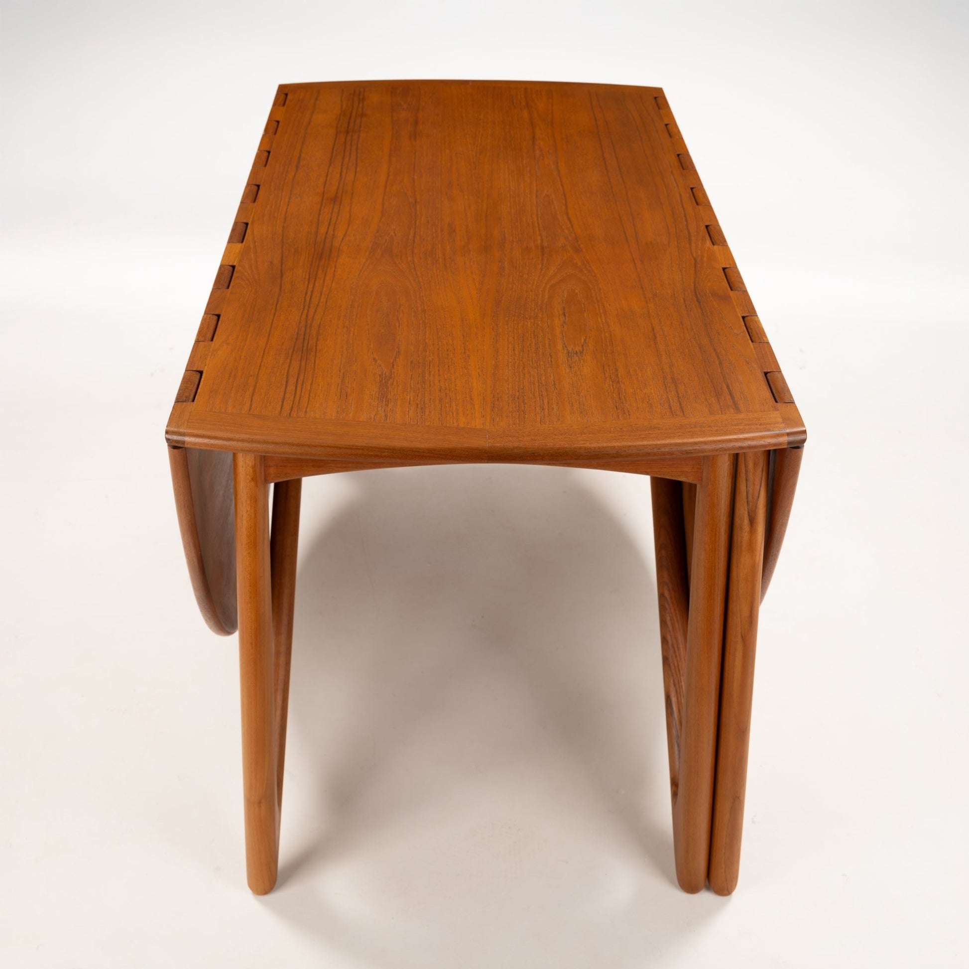 Kurt Ostervig Drop-Leaf Dining Table viewed from the front with closed walnut leaves, tapered sculptural legs, and visible hinges in vintage Danish furniture style
