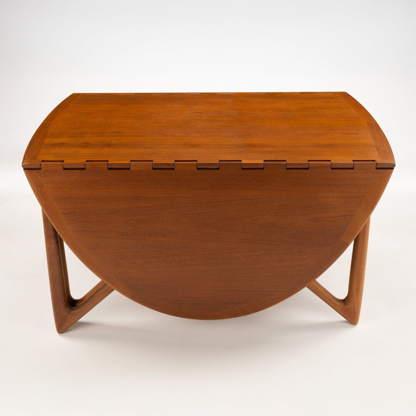Kurt Ostervig Drop-Leaf Dining Table shown closed with folded walnut leaves and sculptural angled legs showcasing warm grain in vintage danish furniture style