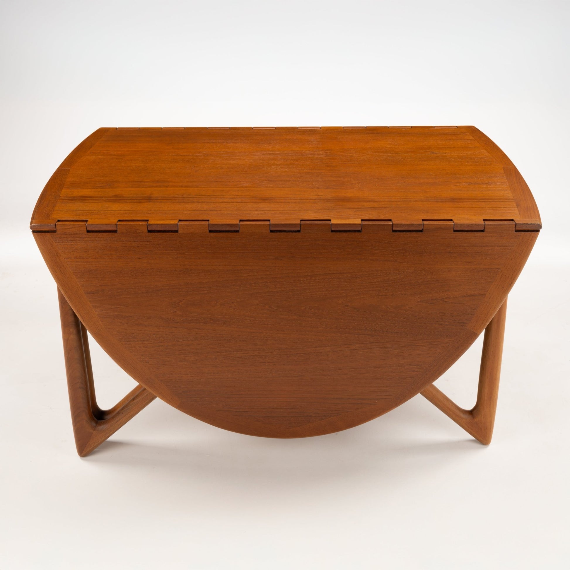 Kurt Ostervig Drop-Leaf Dining Table shown closed with folded walnut leaves and sculptural angled legs showcasing warm grain in vintage danish furniture style