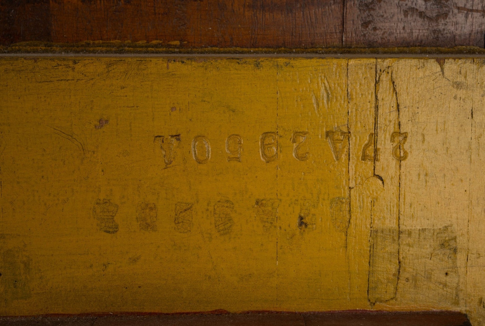 Two-sided wooden industrial machine mold with faded yellow paint and stamped numbers, showcasing vintage patina and wear.