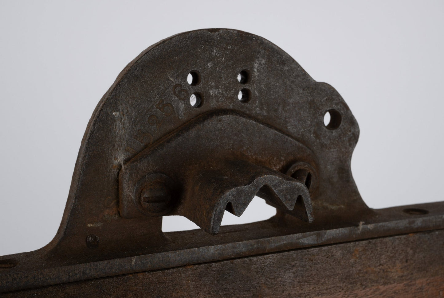 Two-sided industrial wooden machine mold with rusted metal handle and patinated vintage finish on white background.