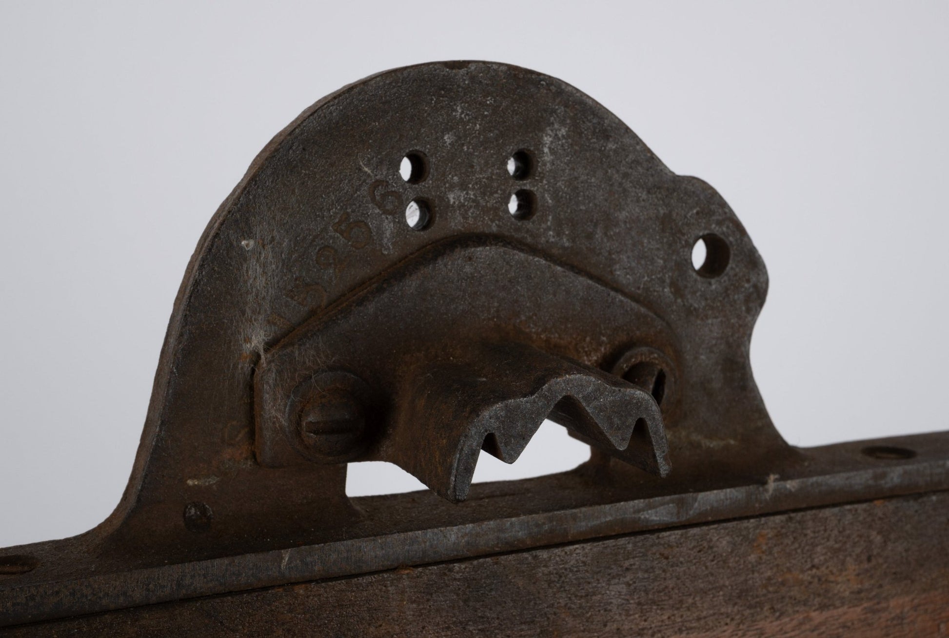 Two-sided industrial wooden machine mold with rusted metal handle and patinated vintage finish on white background.