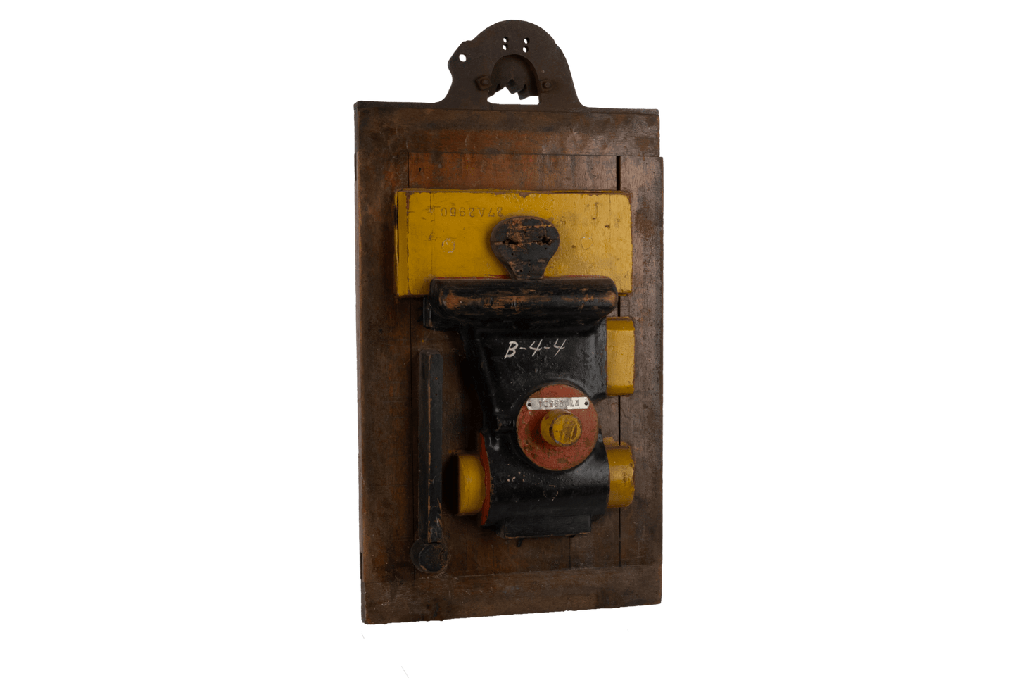 Two-sided vintage industrial machine mold with metal handle, vibrant patina, and yellow and black details on wood panel