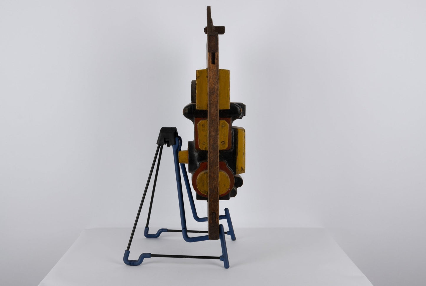 Two-sided vintage industrial wooden machine mold with metal handle and vibrant patina displayed on blue metal stand