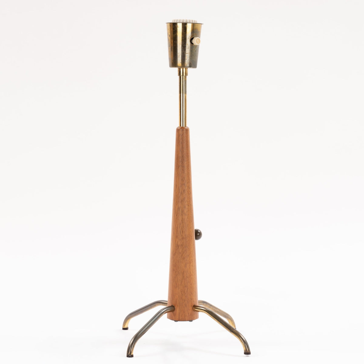 Manner of Josef Frank Table Lamp with tapered wood stem exposed metal socket adjustment knob and curved tripod legs in mid century modern lighting