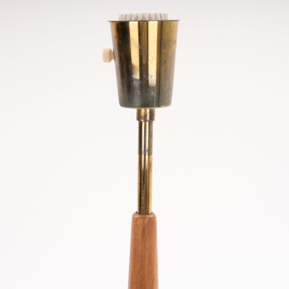 Manner of Josef Frank Table Lamp closeup with tapered wood stem brass shaft and aged metal socket housing in mid century modern lighting