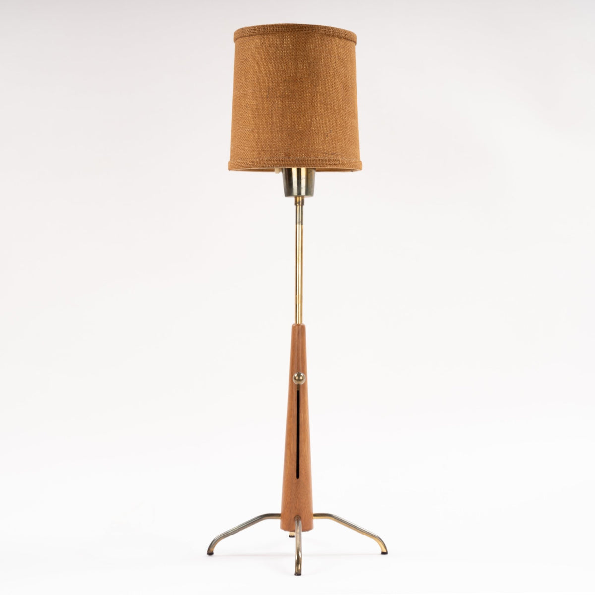 Manner of Josef Frank Table Lamp with tapered wood stem brass rod linen drum shade and curved metal tripod base in mid century modern lighting