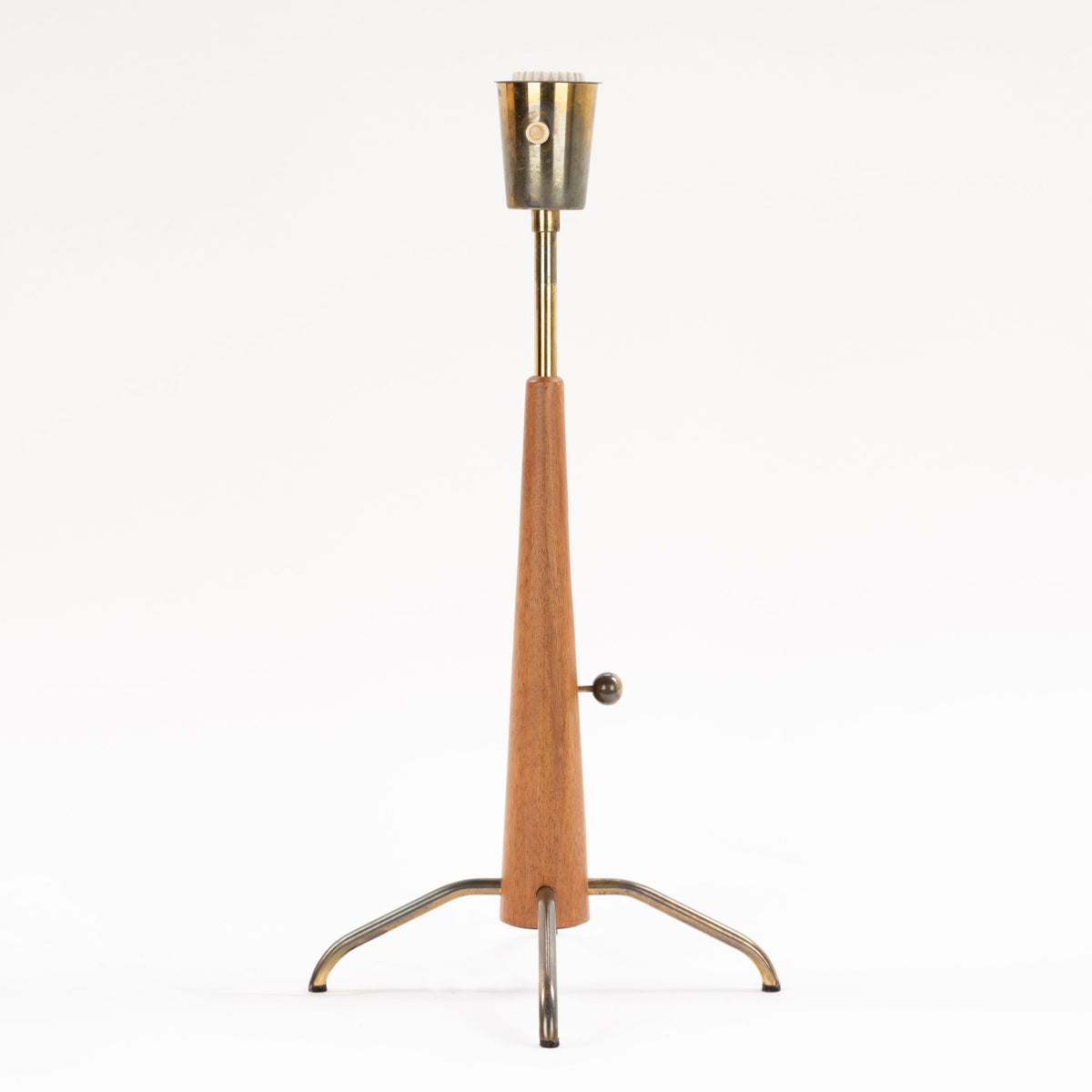 Manner of Josef Frank Table Lamp with tapered wood stem exposed brass socket ratchet knob and curved metal tripod legs in mid century modern lighting