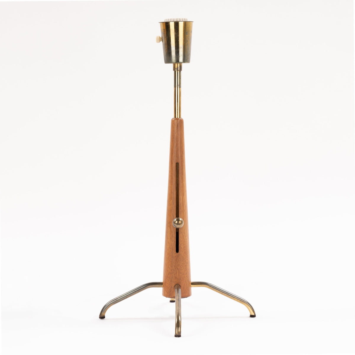 Manner of Josef Frank Table Lamp with tapered wood stem brass rod exposed socket and curved metal tripod base in mid century modern lighting