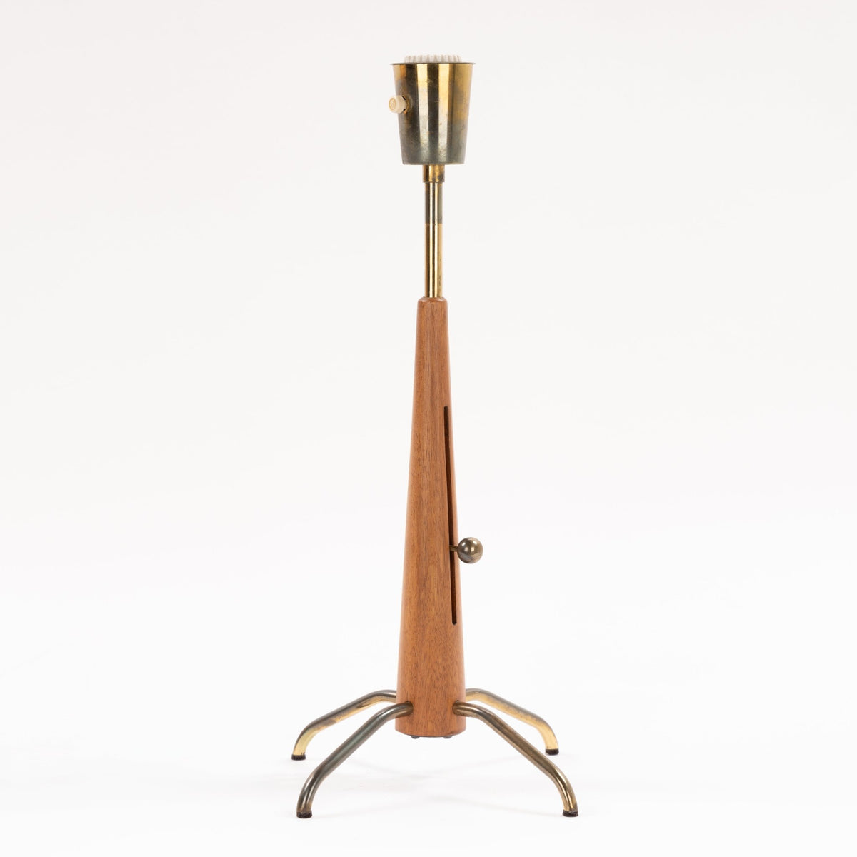 Manner of Josef Frank Table Lamp with tapered wood stem brass shaft exposed socket ratchet knob and curved tripod legs in mid century modern lighting