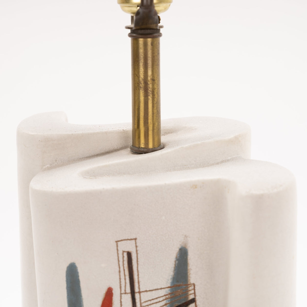 Marianna Von Allesch Table Lamp close up of a white sculptural ceramic base with abstract artwork and aged brass stem in mid century modern lighting