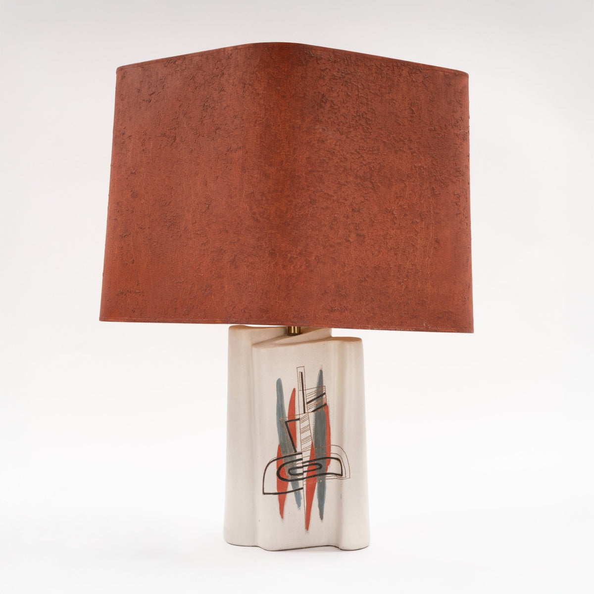Marianna Von Allesch Table Lamp featuring a weathered terracotta shade above a white ceramic base with a geometric red black and gray design for mid century modern lighting