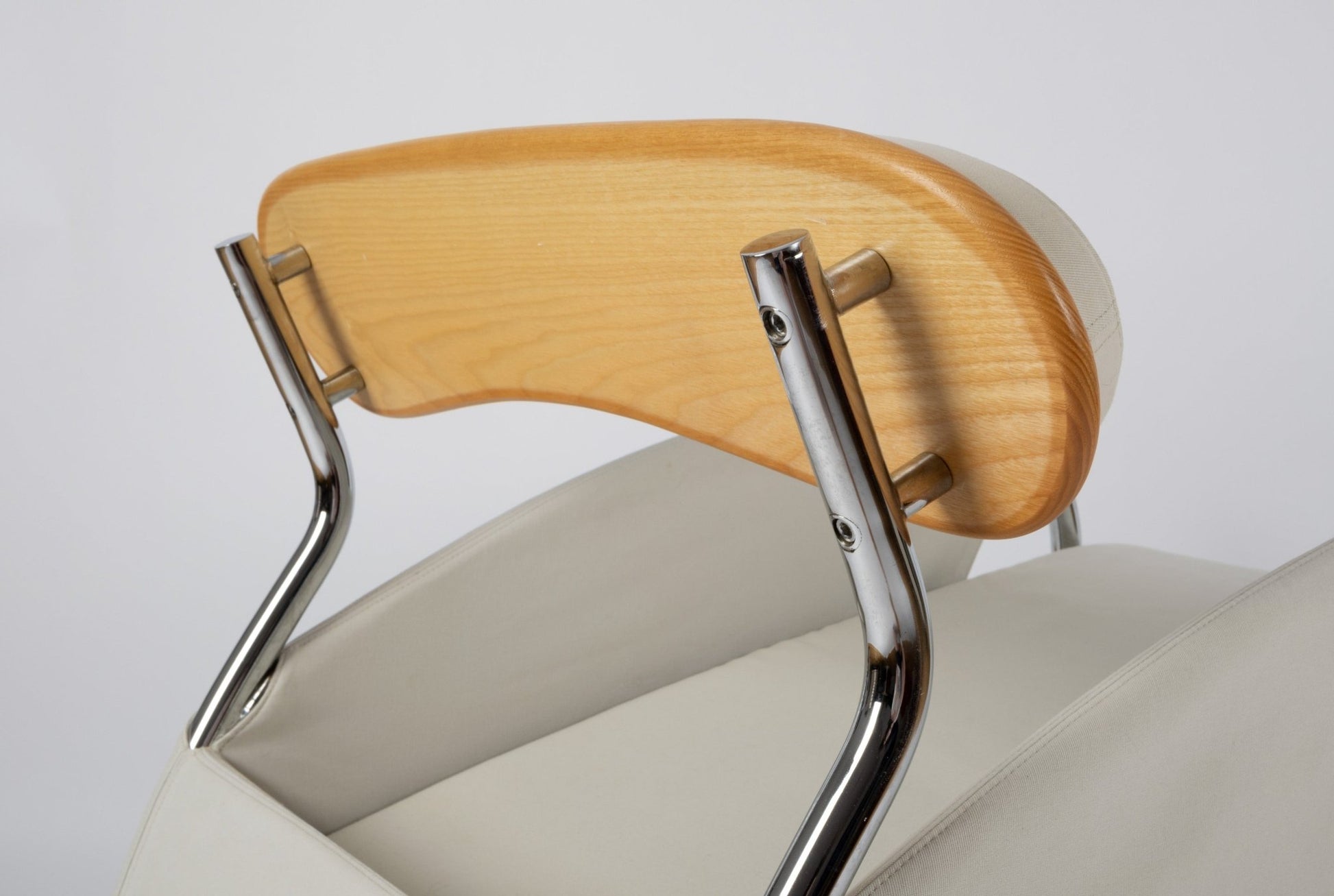 Close-up of Massimo Iosa Ghini Memphis-style arm chair backrest with chrome frame and curved wooden support from the 1980s
