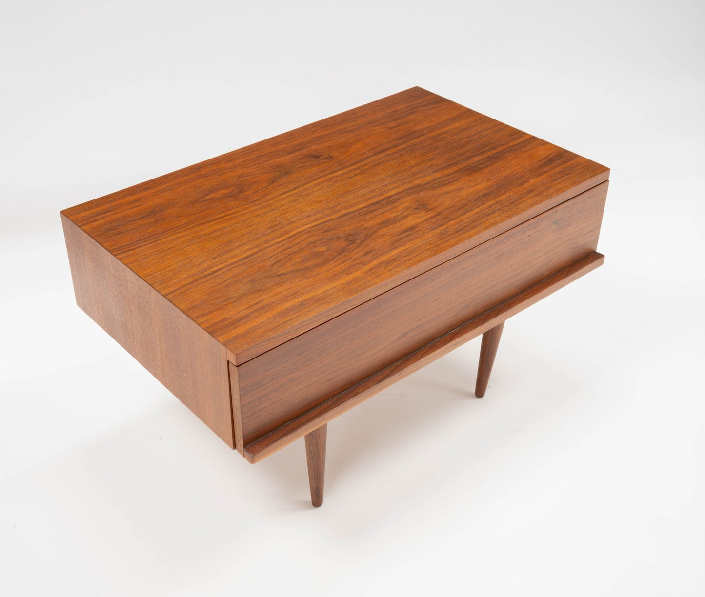 Mid-century modern walnut side table with rectangular top, single drawer, and tapered legs by Mel Smilow.