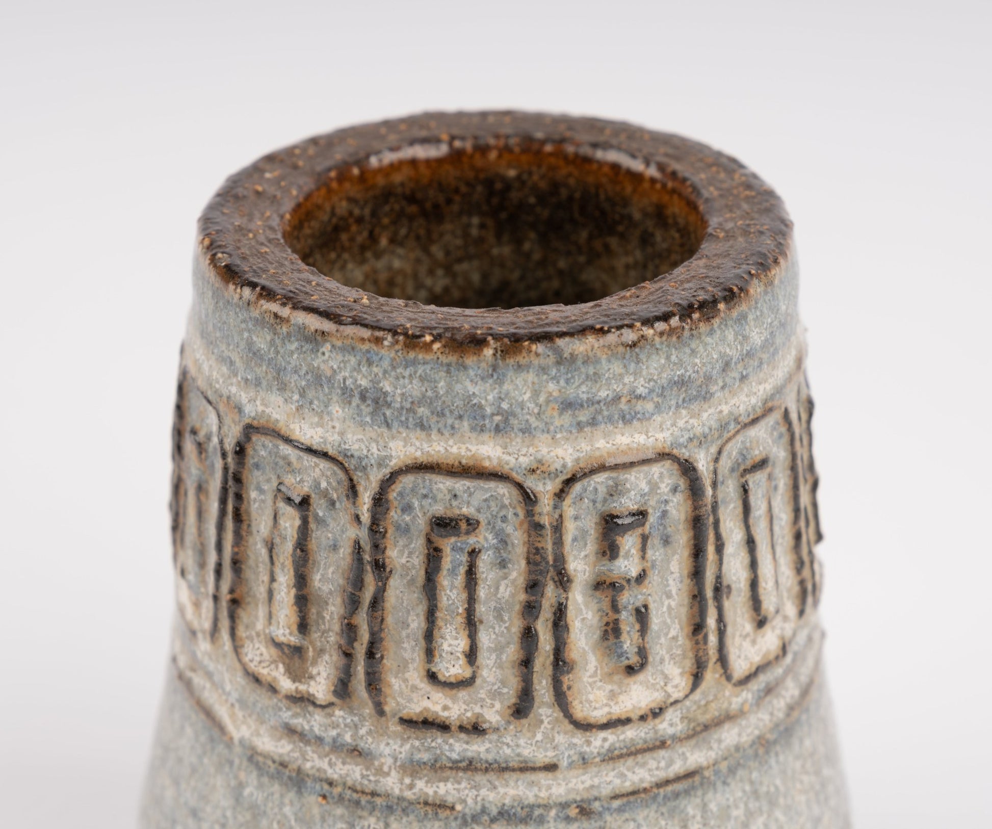 Close-up of Michael Andersen stoneware vase with carved geometric relief band and textured glaze finish
