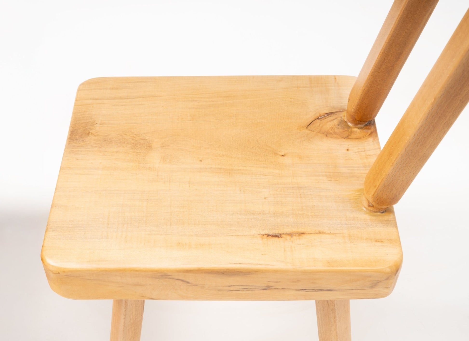 Close-up of Mobichalet Brutalist oversized pine chair seat showing smooth grain and sturdy spindle backrest from Belgium